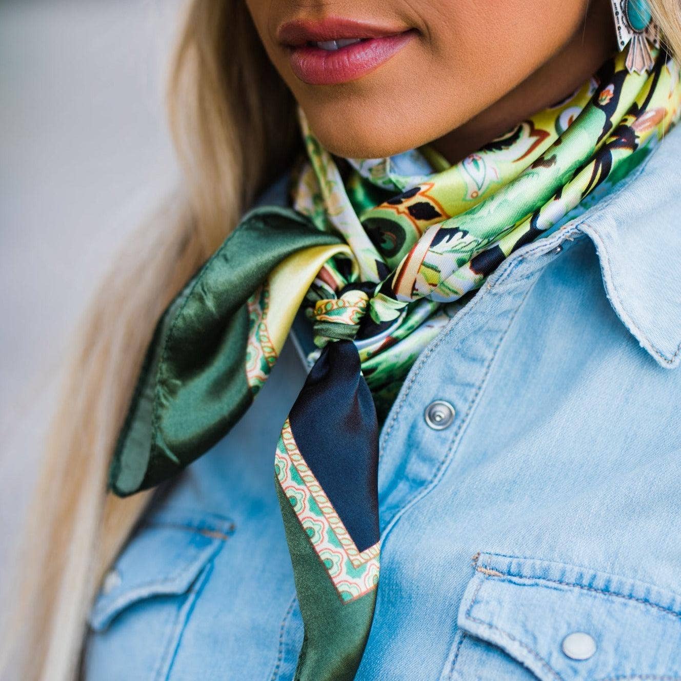 Woman wearing a colorful scarf and denim jacket with a neutral background