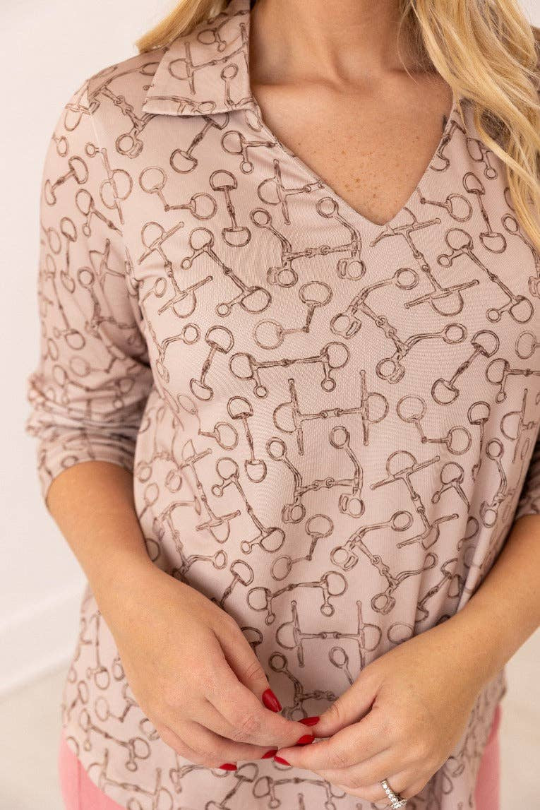 Close up front view of V-neck stretch top with roll-tab sleeves in a relaxed fit tan with brown horse bit pattern all over top