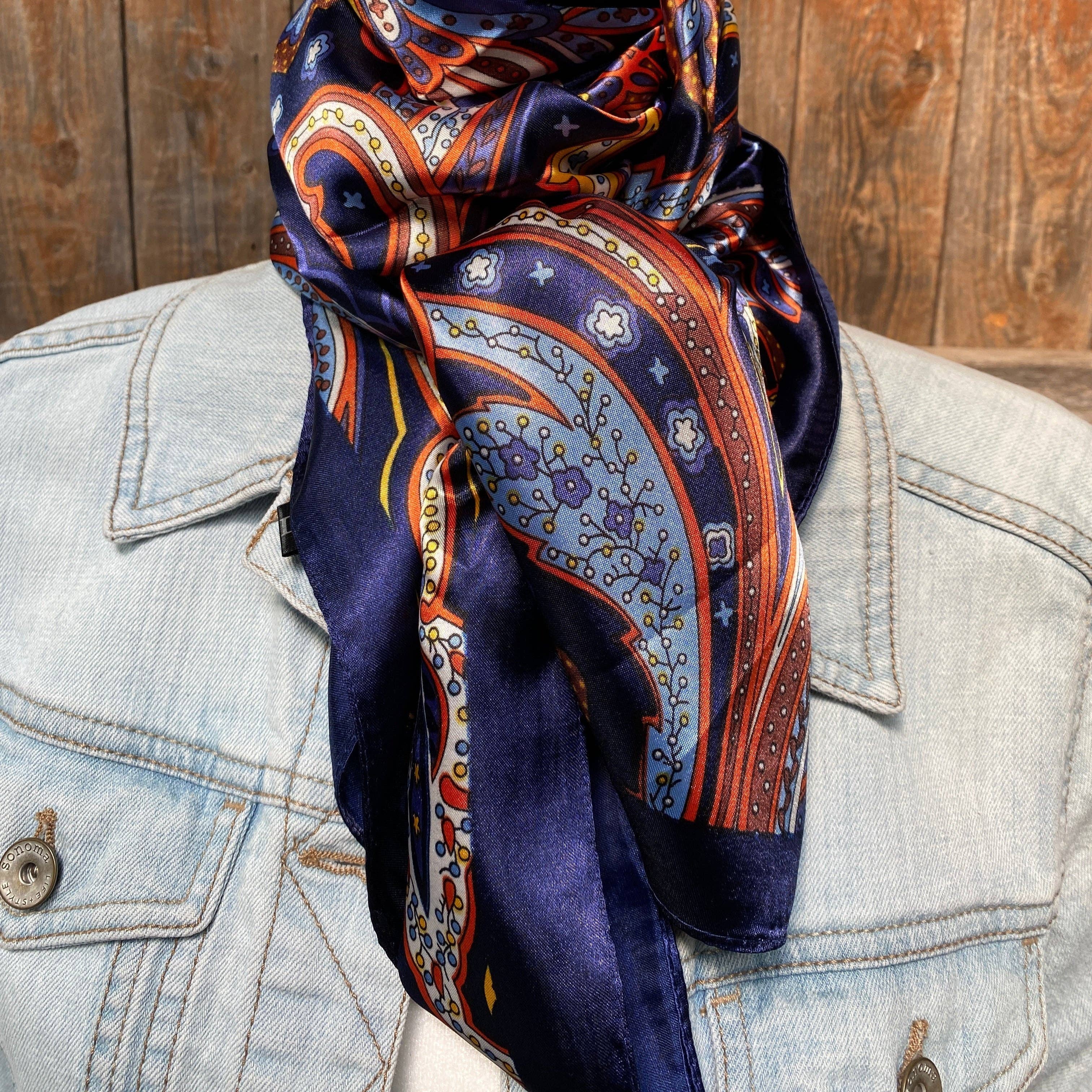 Patterned scarf draped over a denim jacket against a wooden background