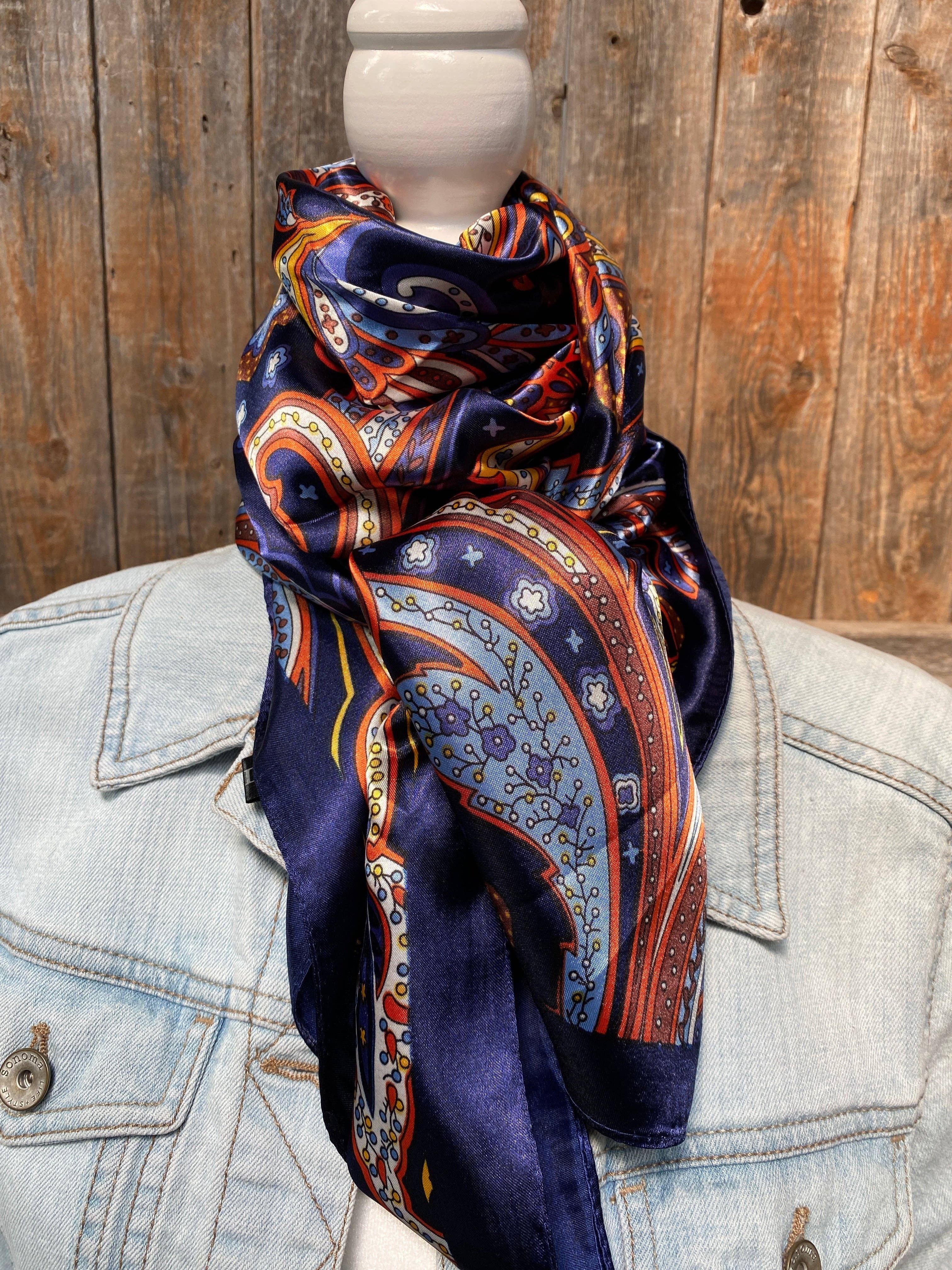 Patterned scarf draped over a denim jacket against a wooden background