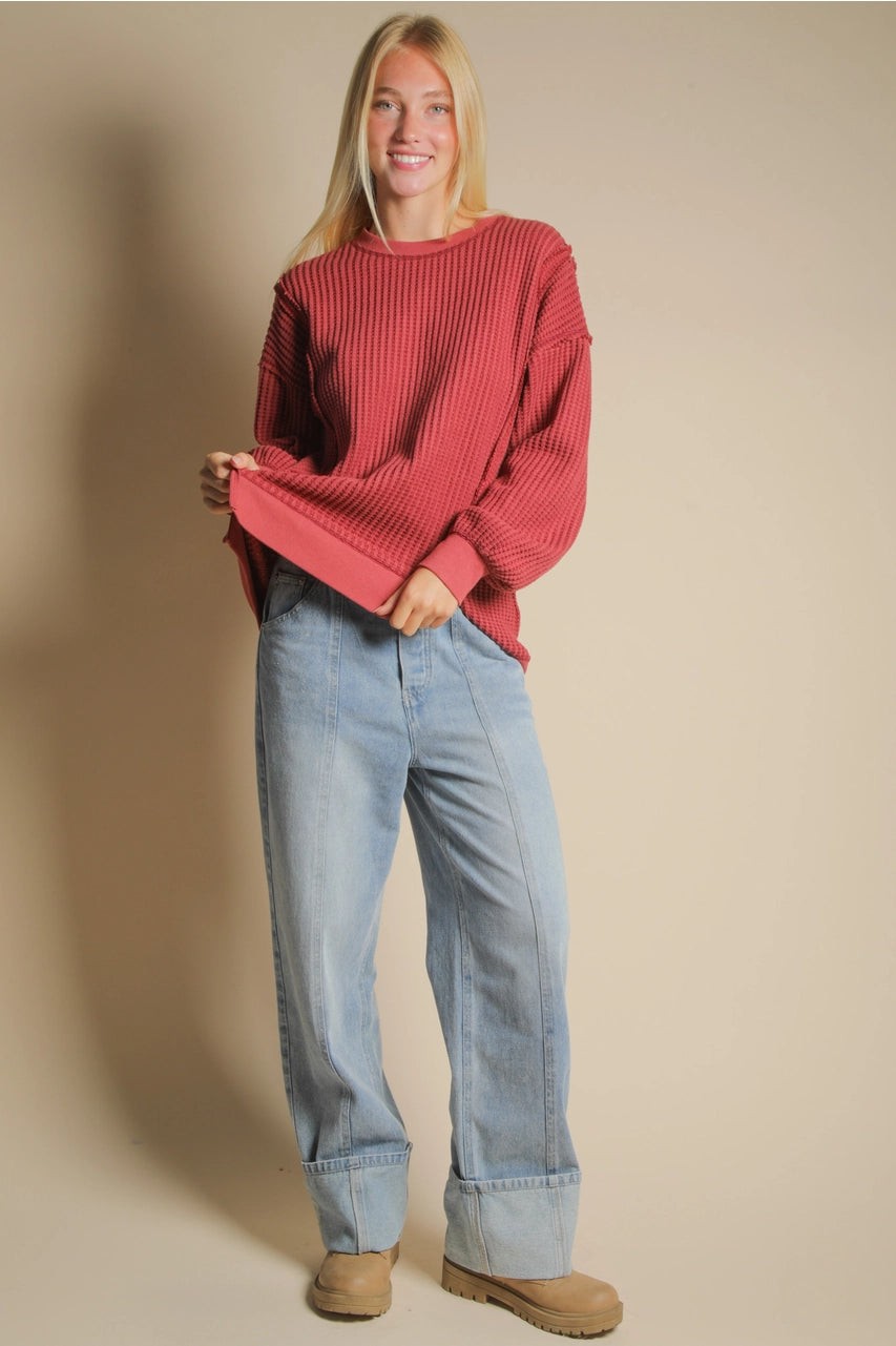 Front view of burgundy oversized waffle knit top with round neck and drop shoulders.