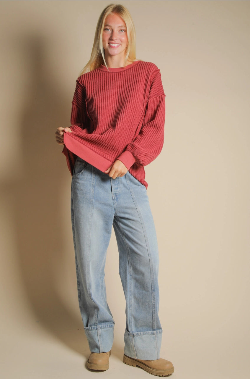 Front view of burgundy oversized waffle knit top with round neck and drop shoulders.