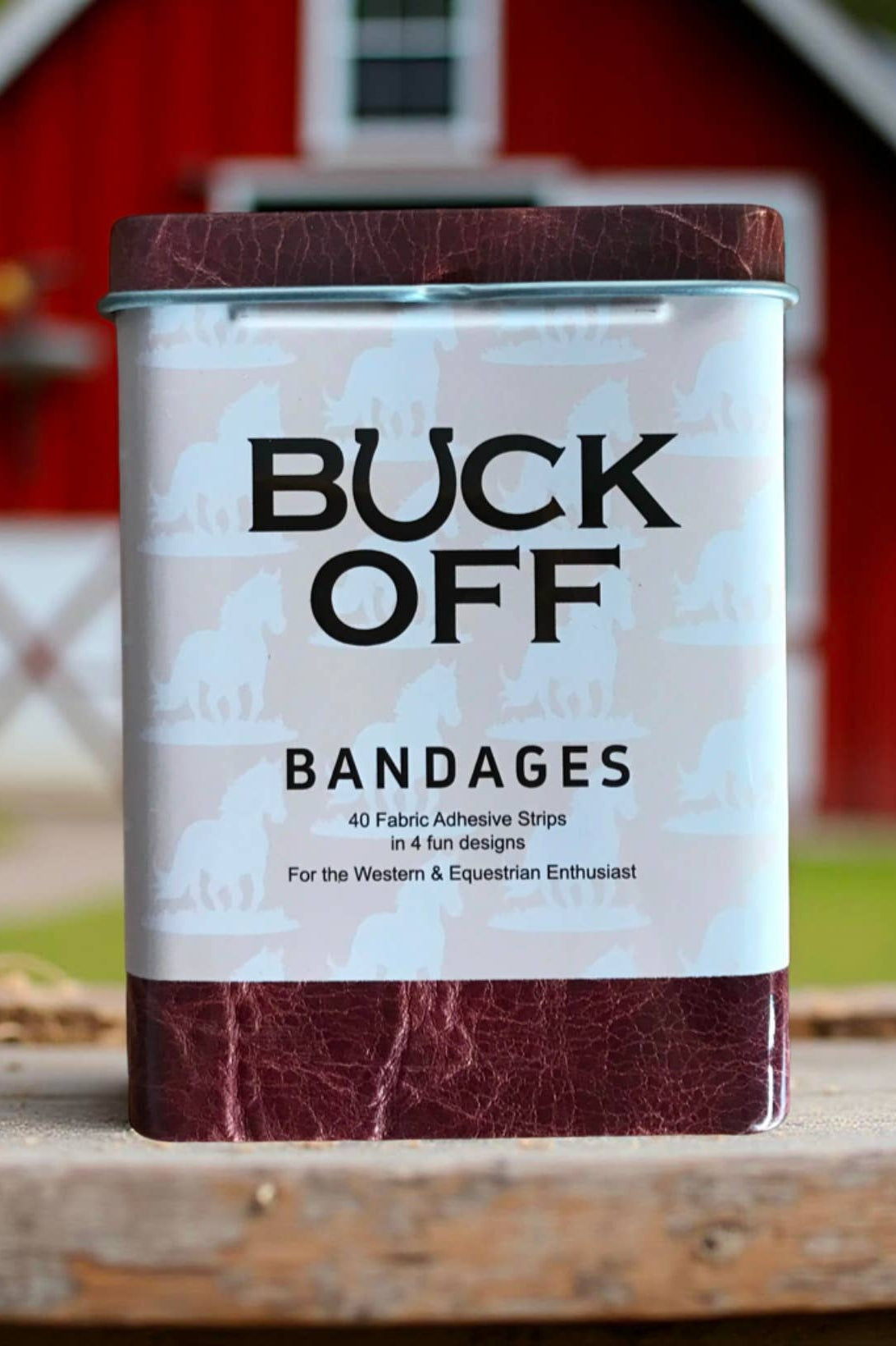 Can of Buck Off bandages with a barn in the background