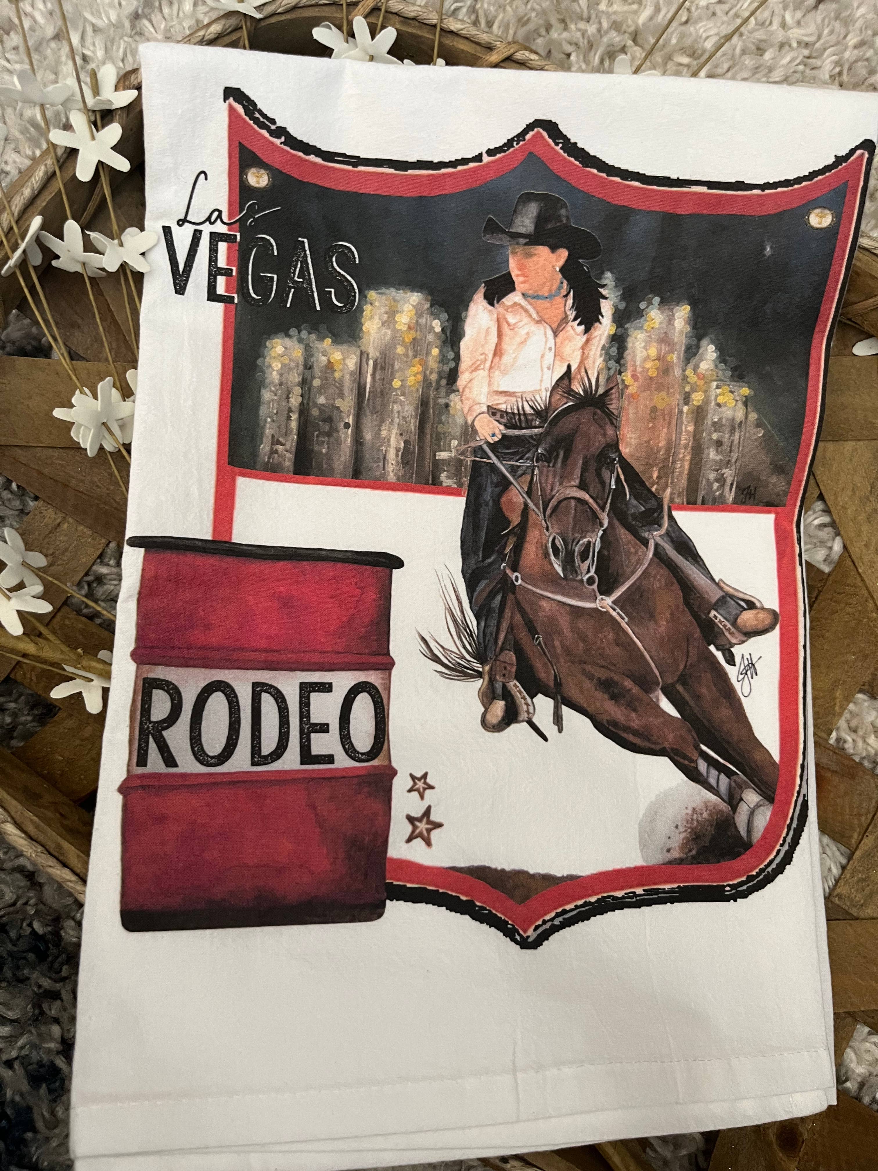 Tea towel with a rodeo design featuring a cowgirl on a horse and a barrel, with 'Las Vegas Rodeo' text.