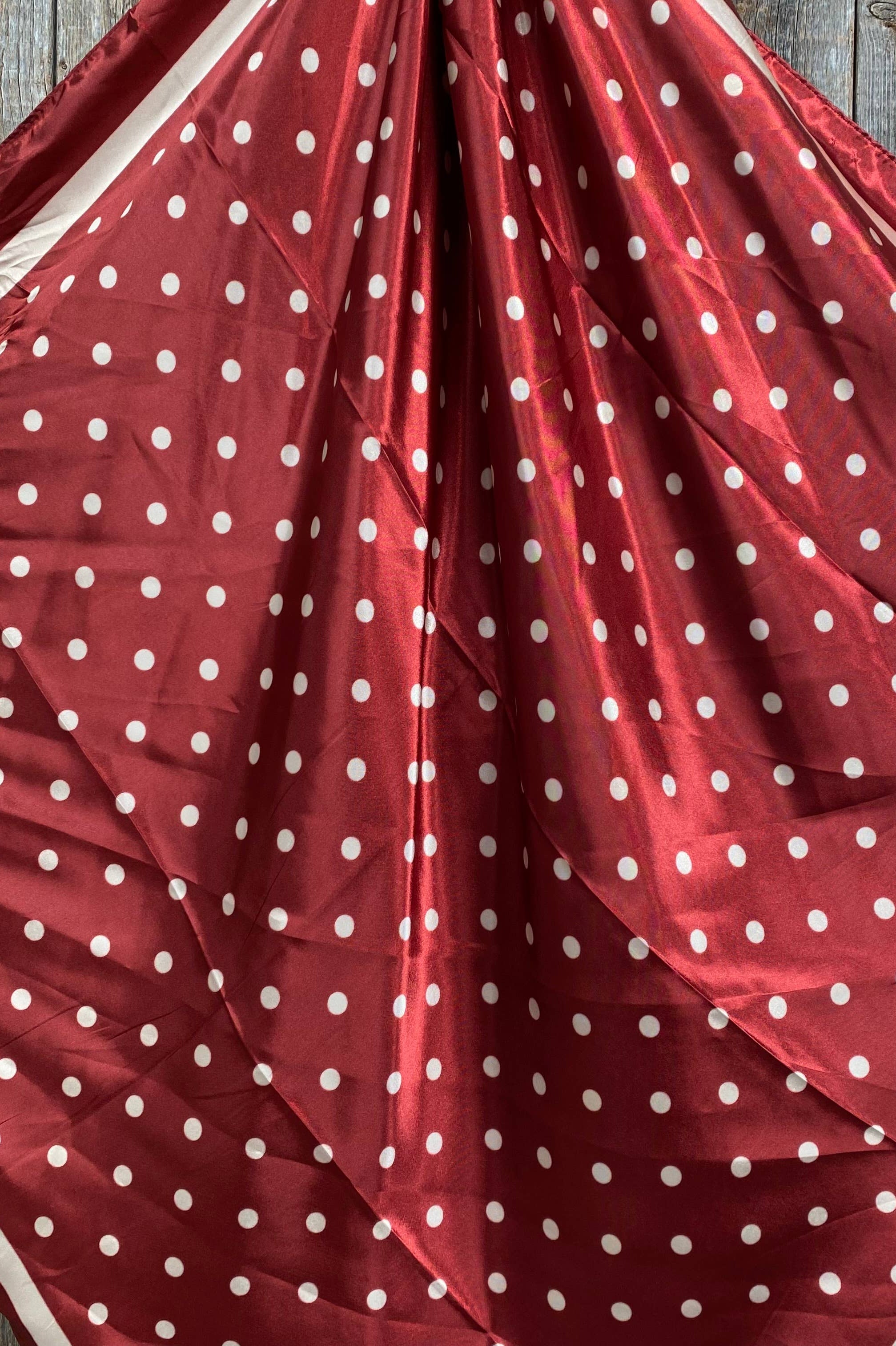 Red fabric with white polka dots on a wooden surface