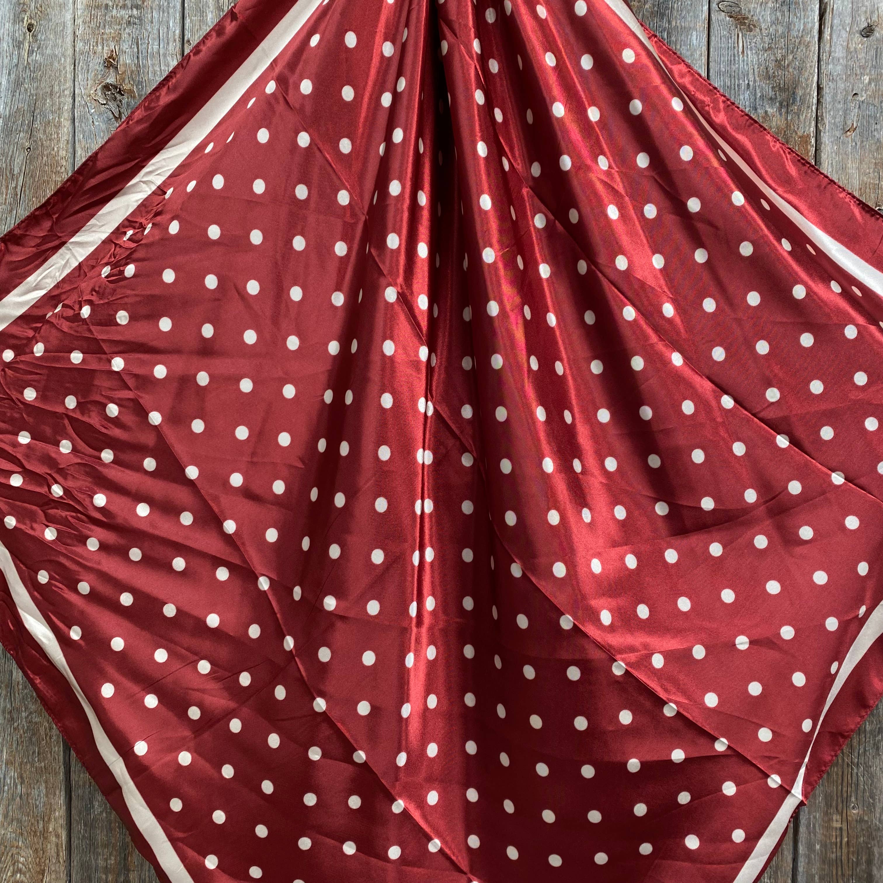 Red fabric with white polka dots on a wooden surface
