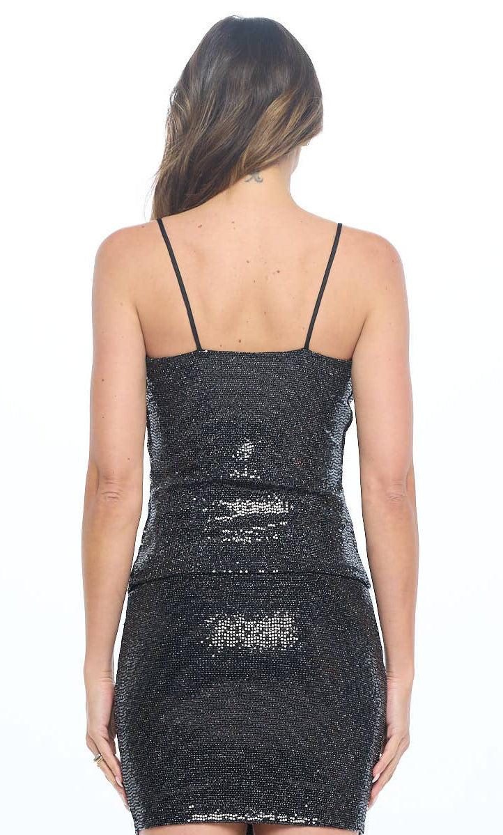 Black sequin tank and skirt worn by a model on a white background