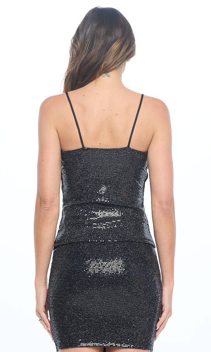 Black sequin tank and skirt worn by a model on a white background
