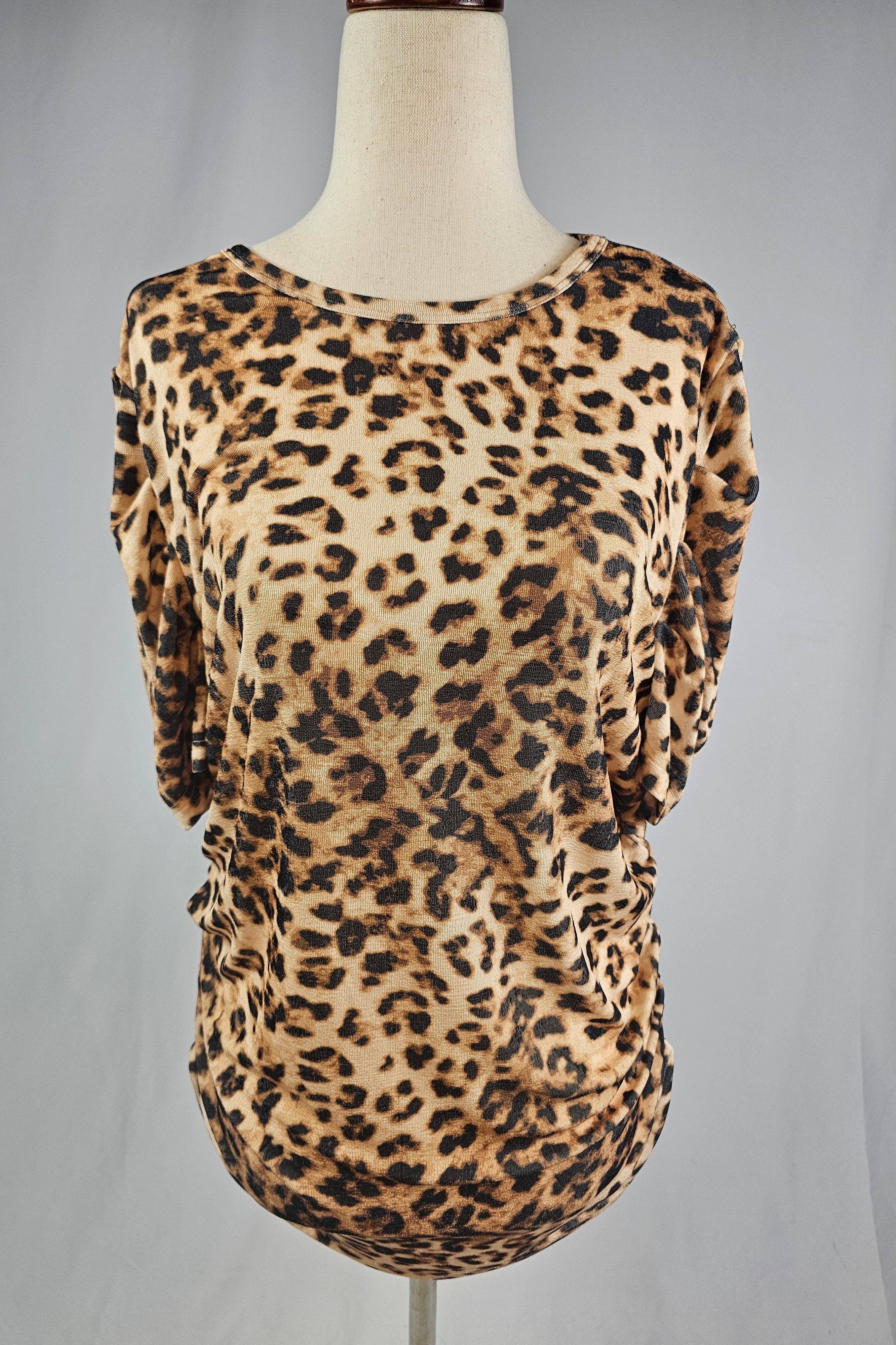 Leopard print top on a mannequin against a gray background