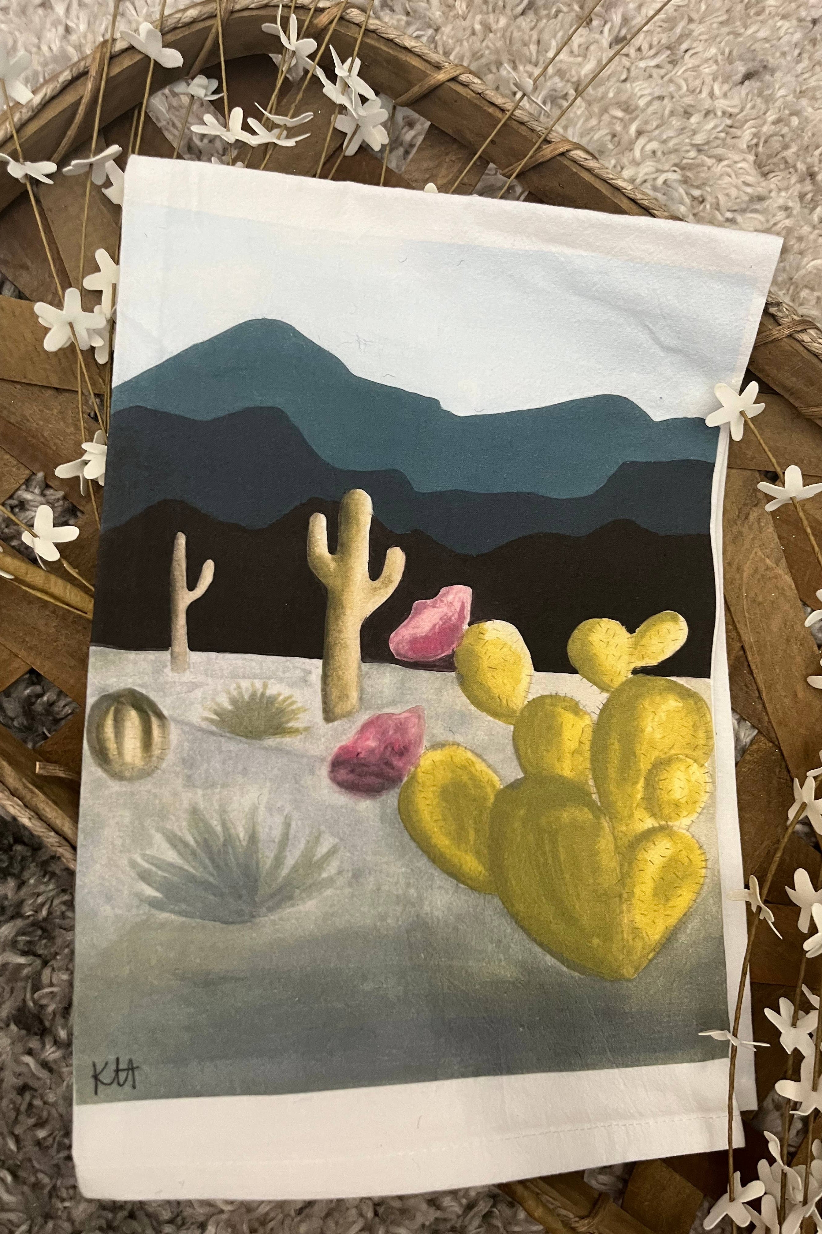 Painting of a desert scene with cacti on a white tea towel.