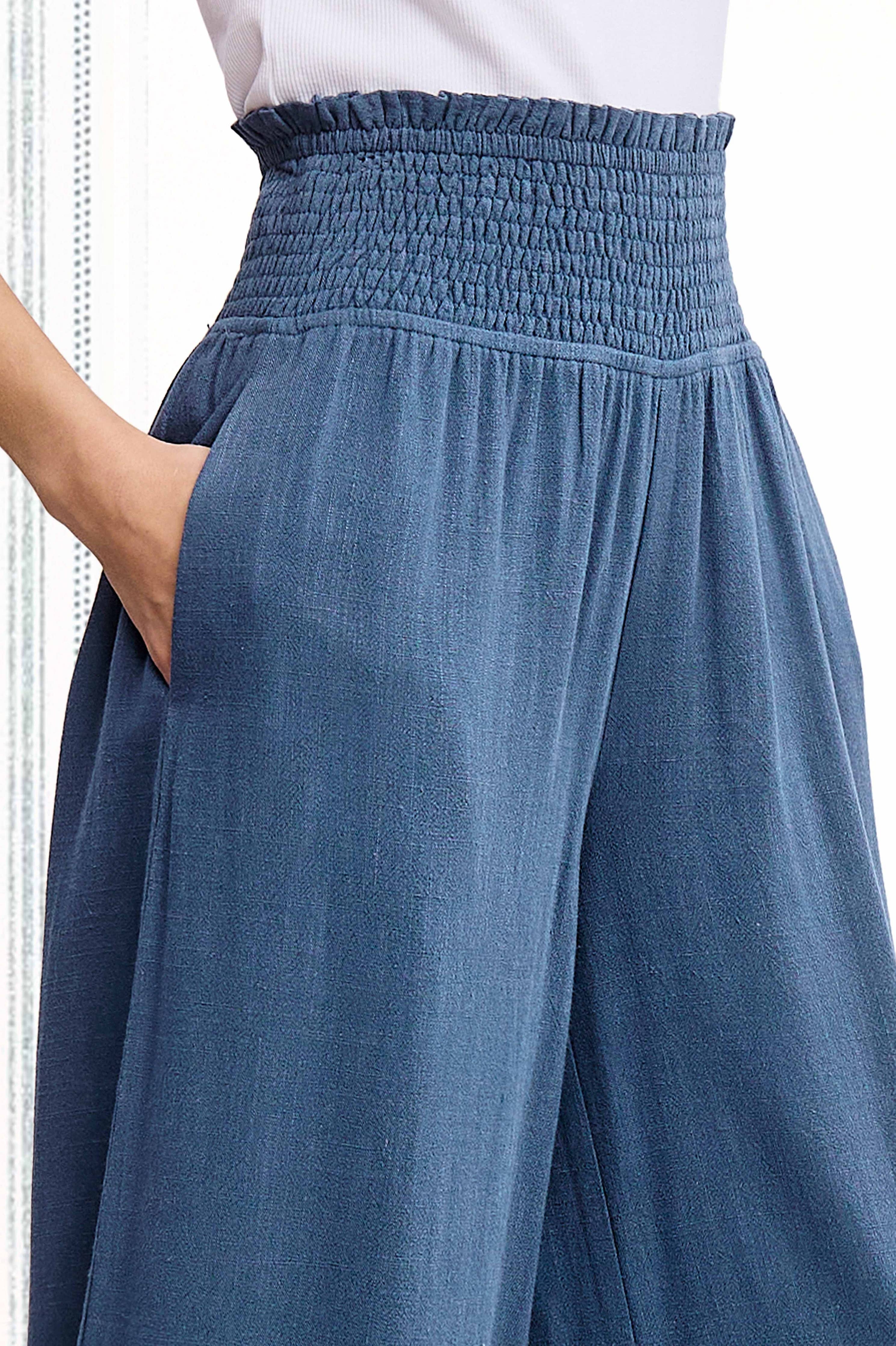 Blue wide-leg pants with a white top on a white background