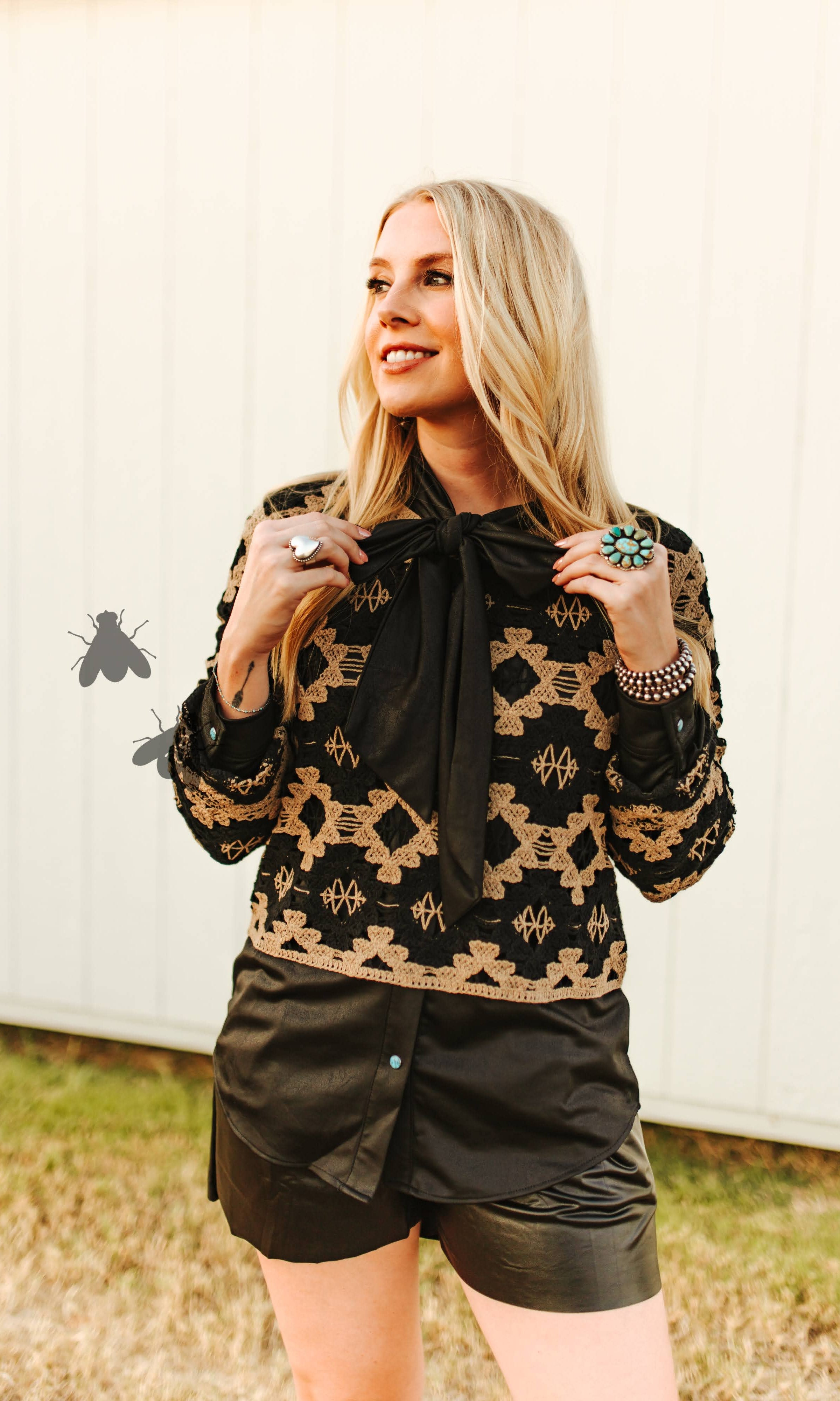 Woman wearing a patterned jacket and black shorts outdoors