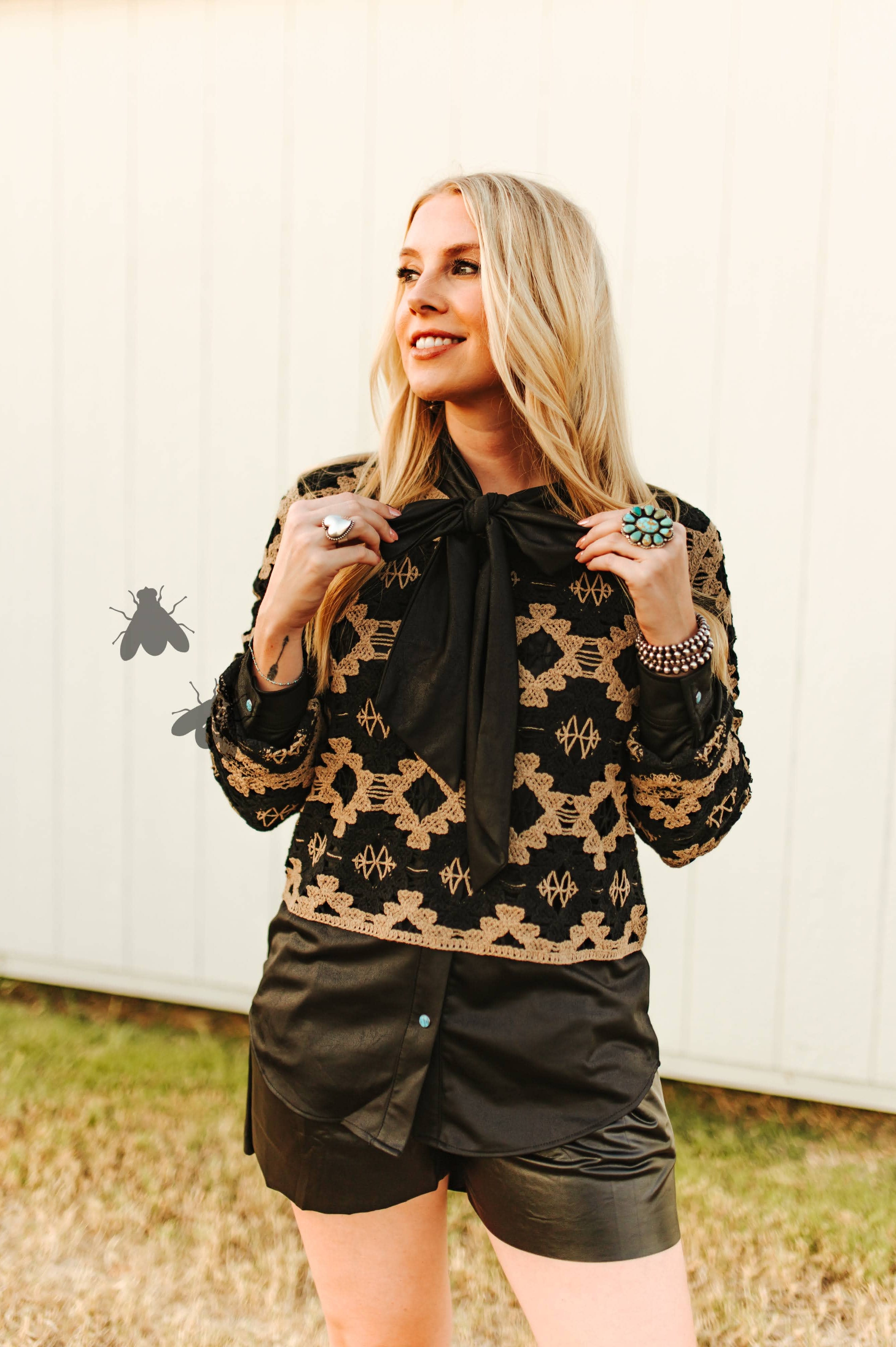 Woman wearing a patterned jacket and black shorts outdoors