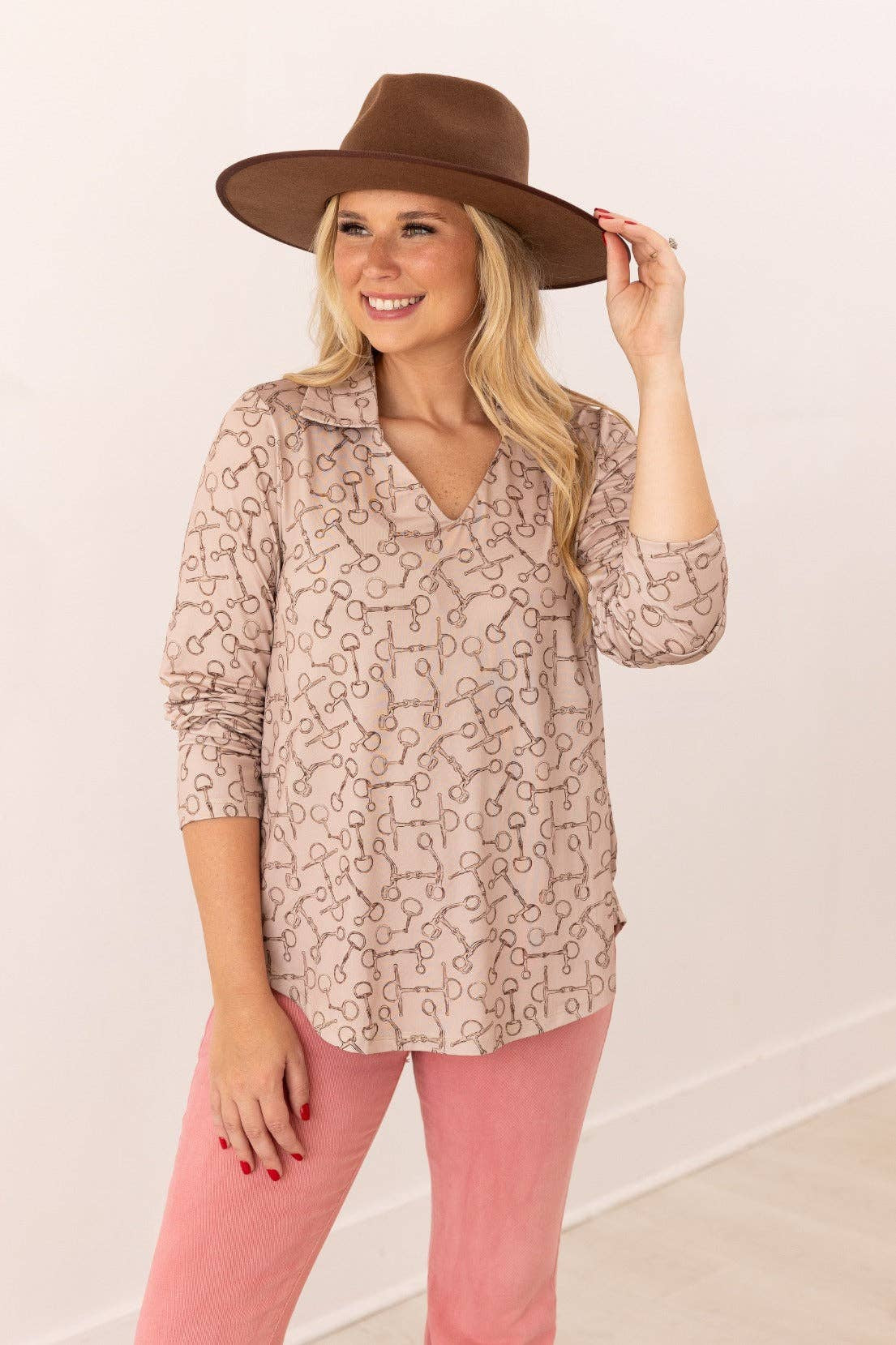 Front view of V-neck stretch top with roll-tab sleeves in a relaxed fit tan with brown horse bit pattern all over top