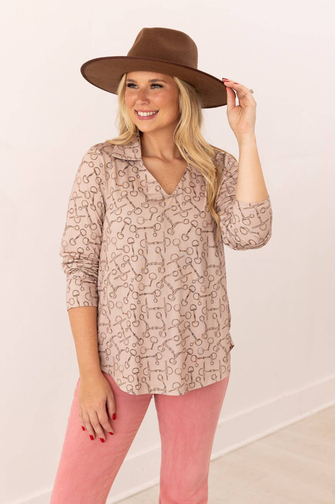 Front view of V-neck stretch top with roll-tab sleeves in a relaxed fit tan with brown horse bit pattern all over top