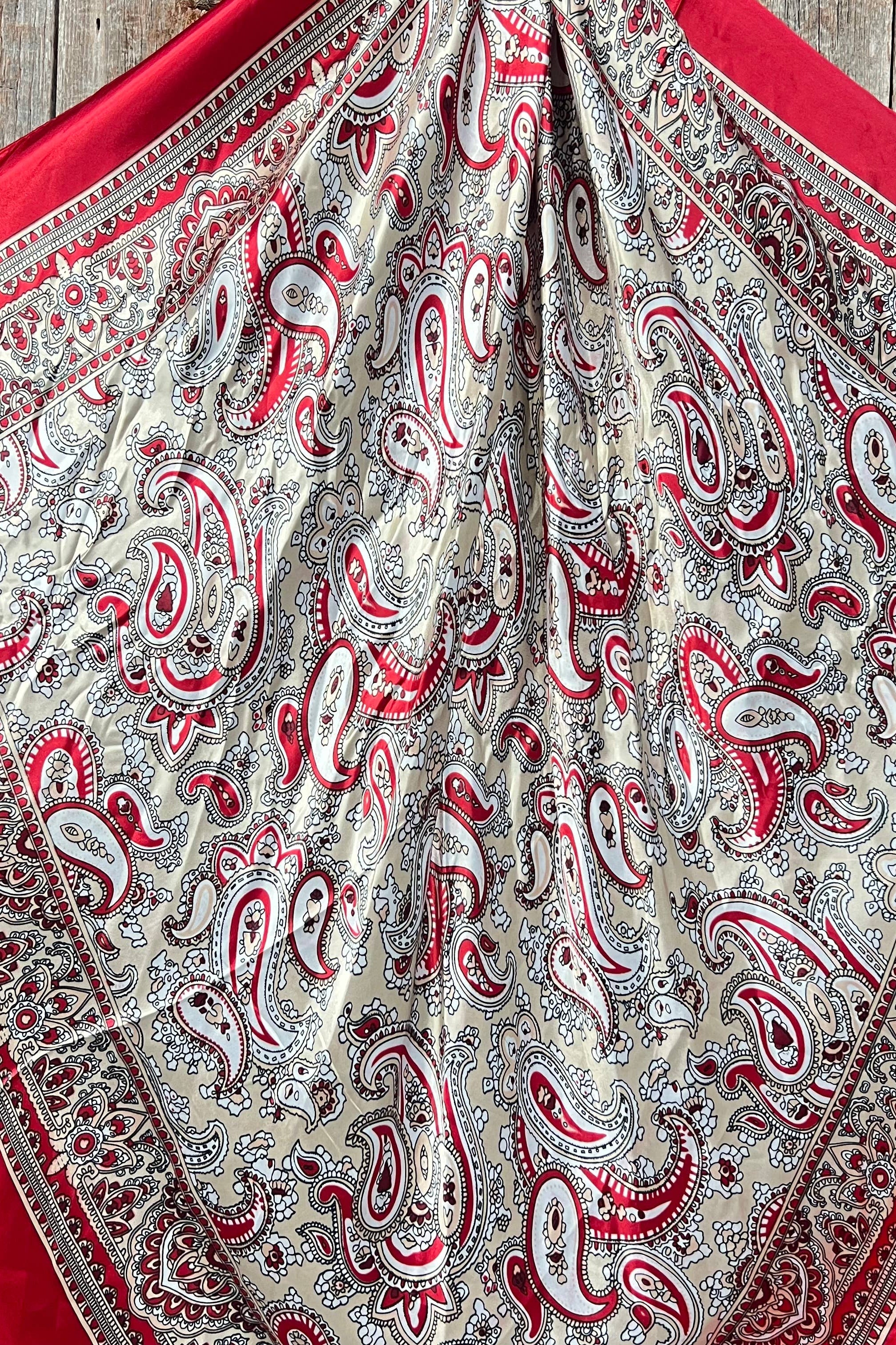 Red and white paisley patterned fabric on a wooden surface
