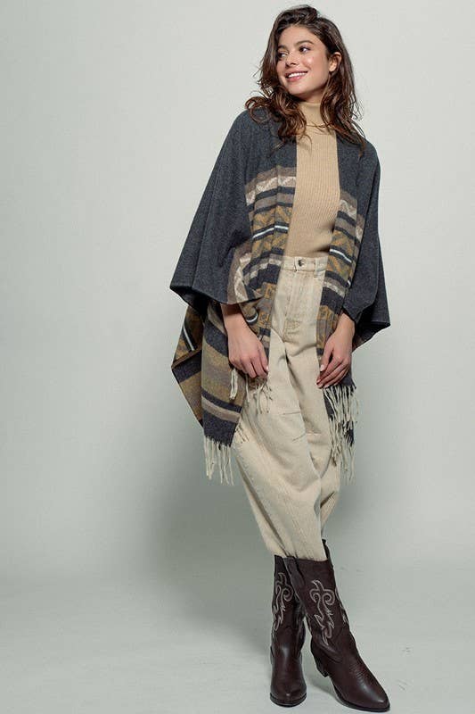 Dark gray poncho with brown and beige striped pattern and fringes on a white background