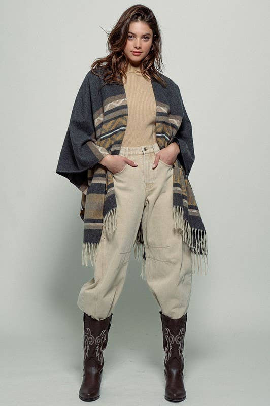 Dark gray poncho with brown and beige striped pattern and fringes on a white background