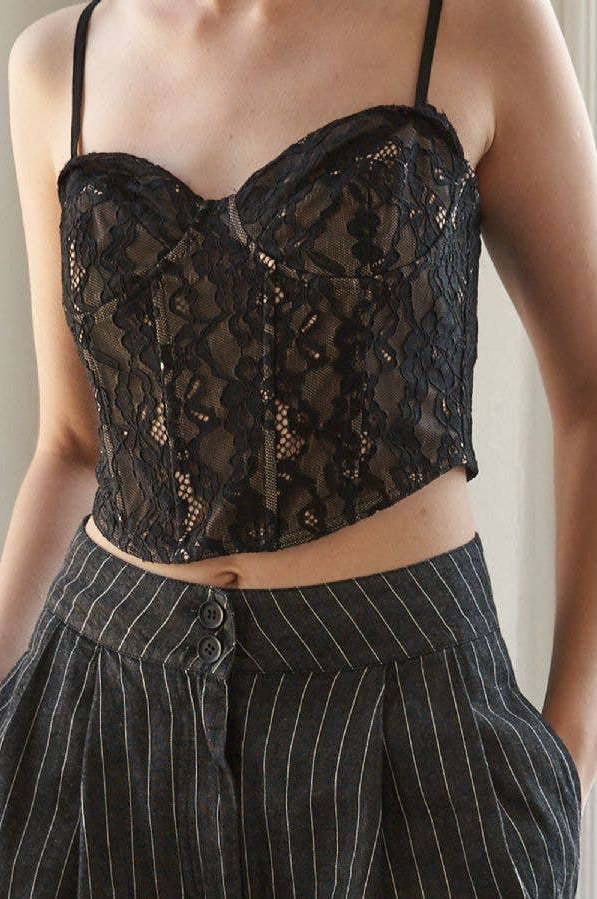 Black lace top worn by a person with a neutral background