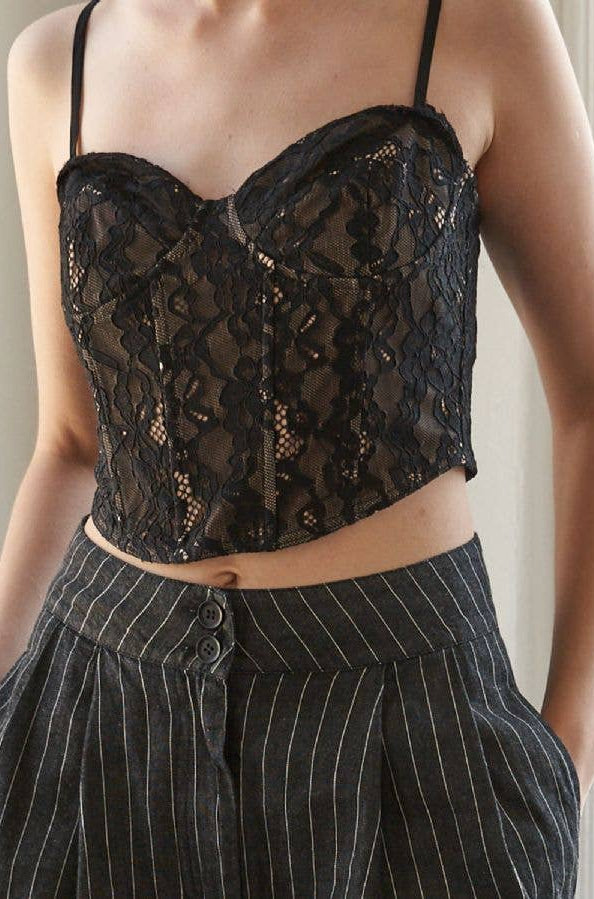 Black lace top worn by a person with a neutral background