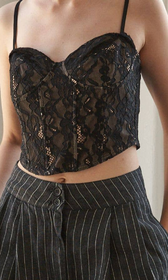 Black lace top worn by a person with a neutral background