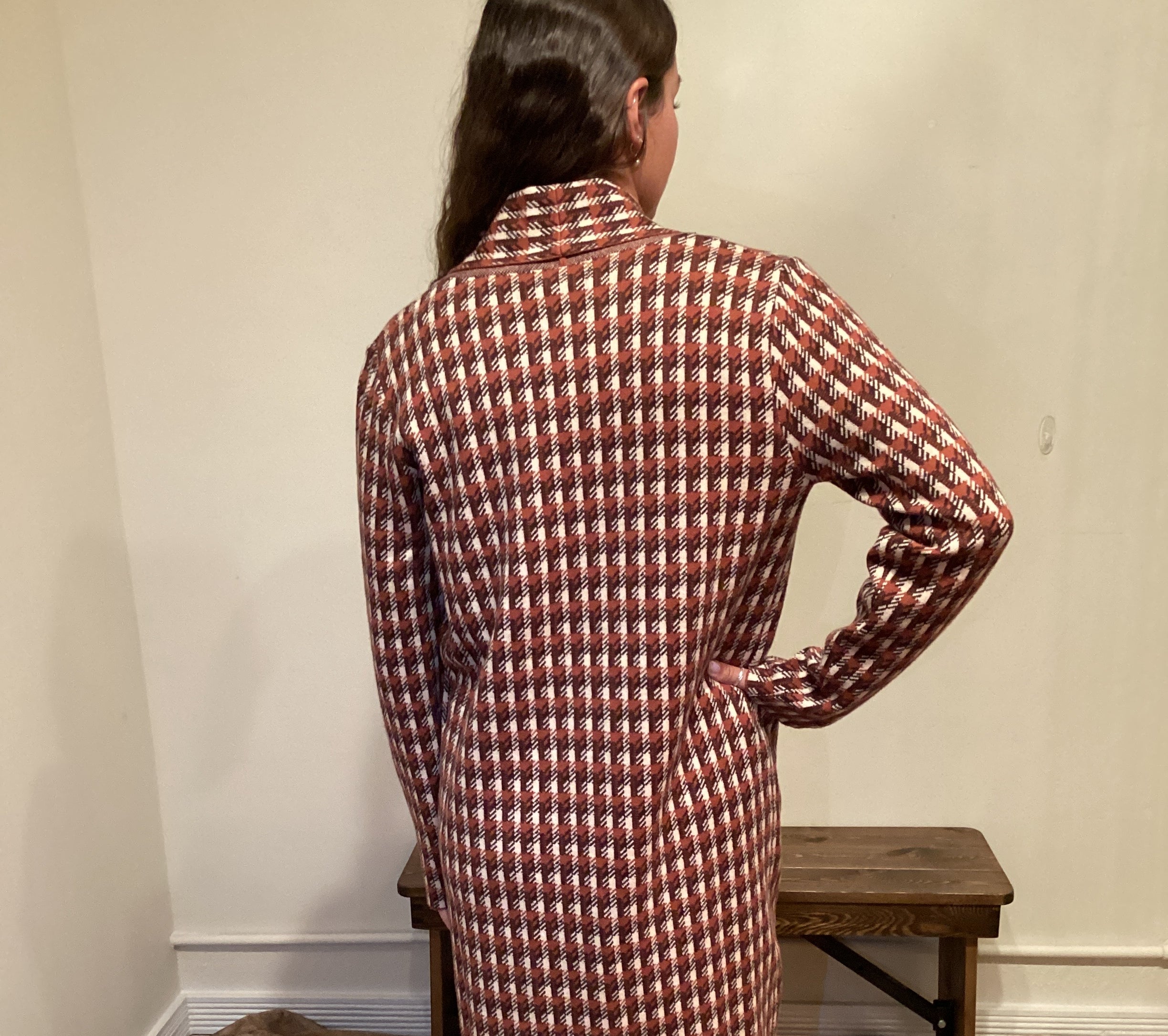back view Rust and brown check pattern long cardigan with a single button and pockets hits mid shin