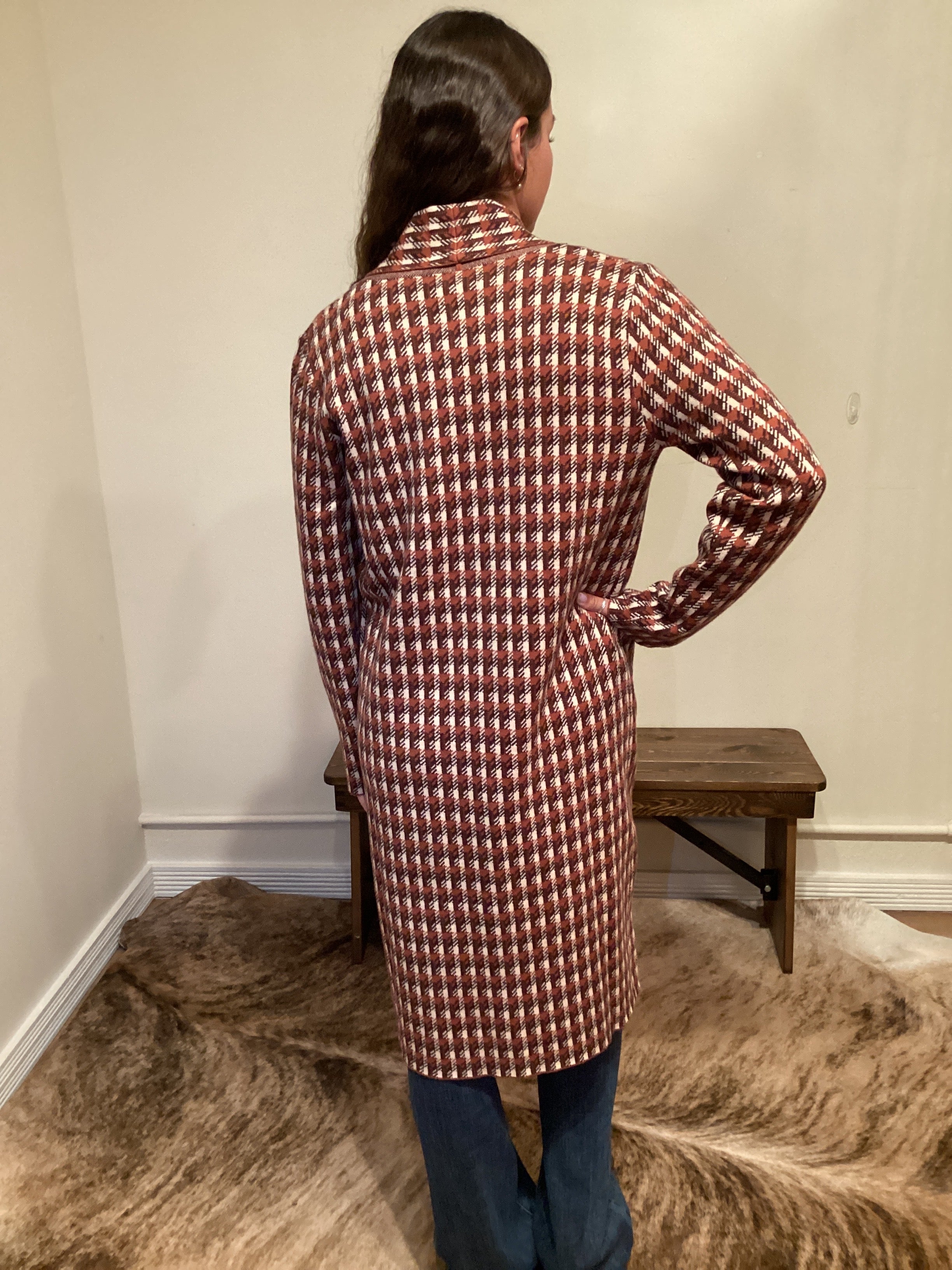 back view Rust and brown check pattern long cardigan with a single button and pockets hits mid shin