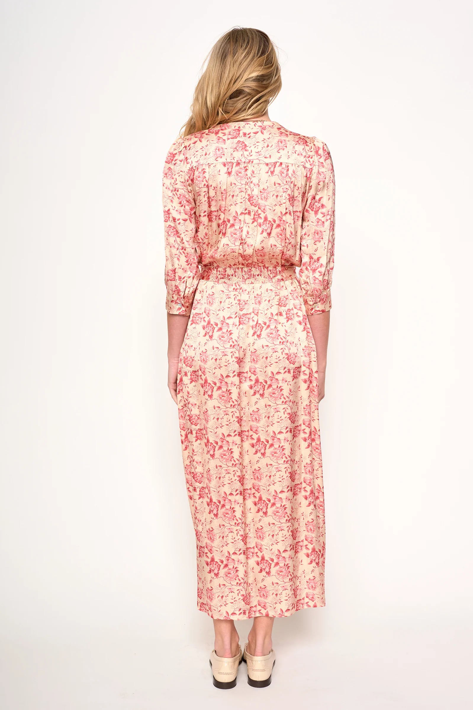 Woman wearing a red floral dress on a white background