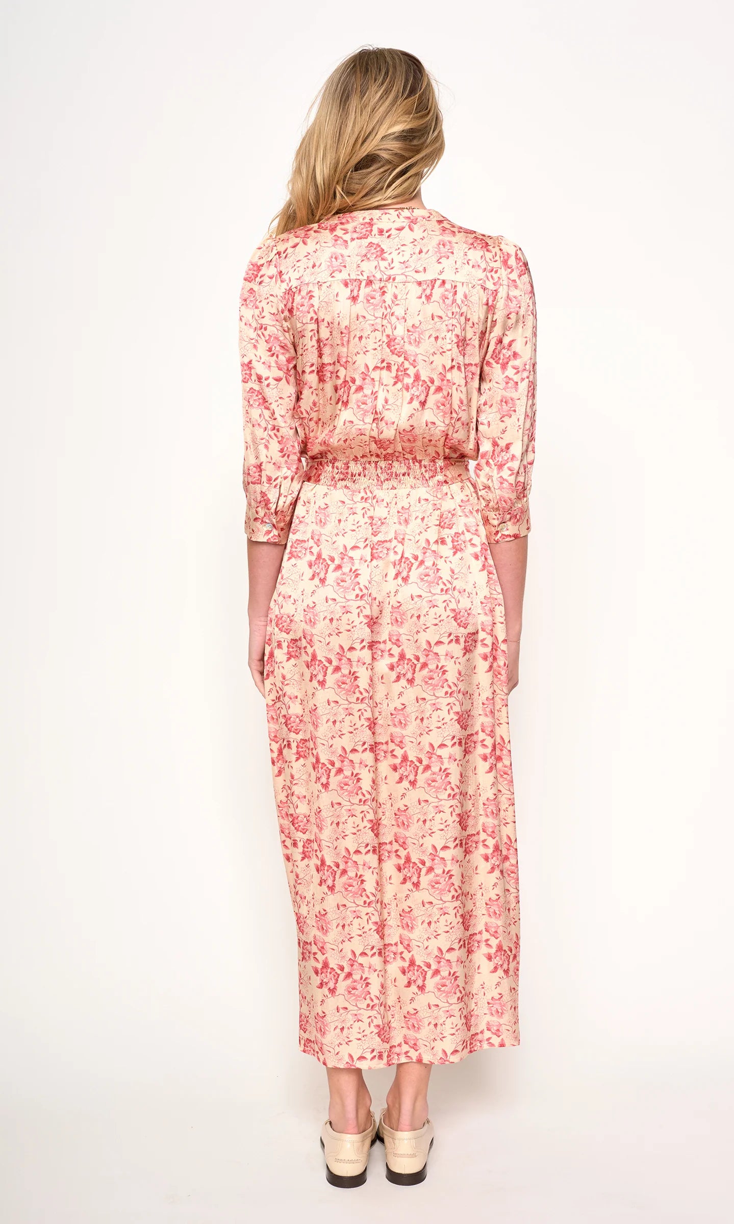 Woman wearing a red floral dress on a white background