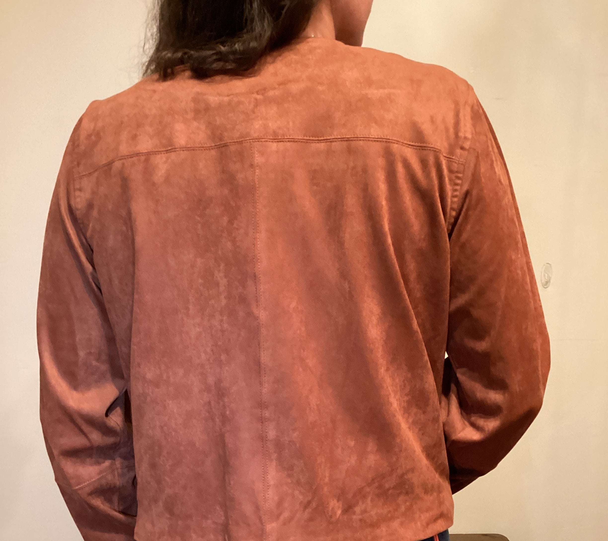 Back View Person wearing a brown faux leather button up jacket and blue jeans
