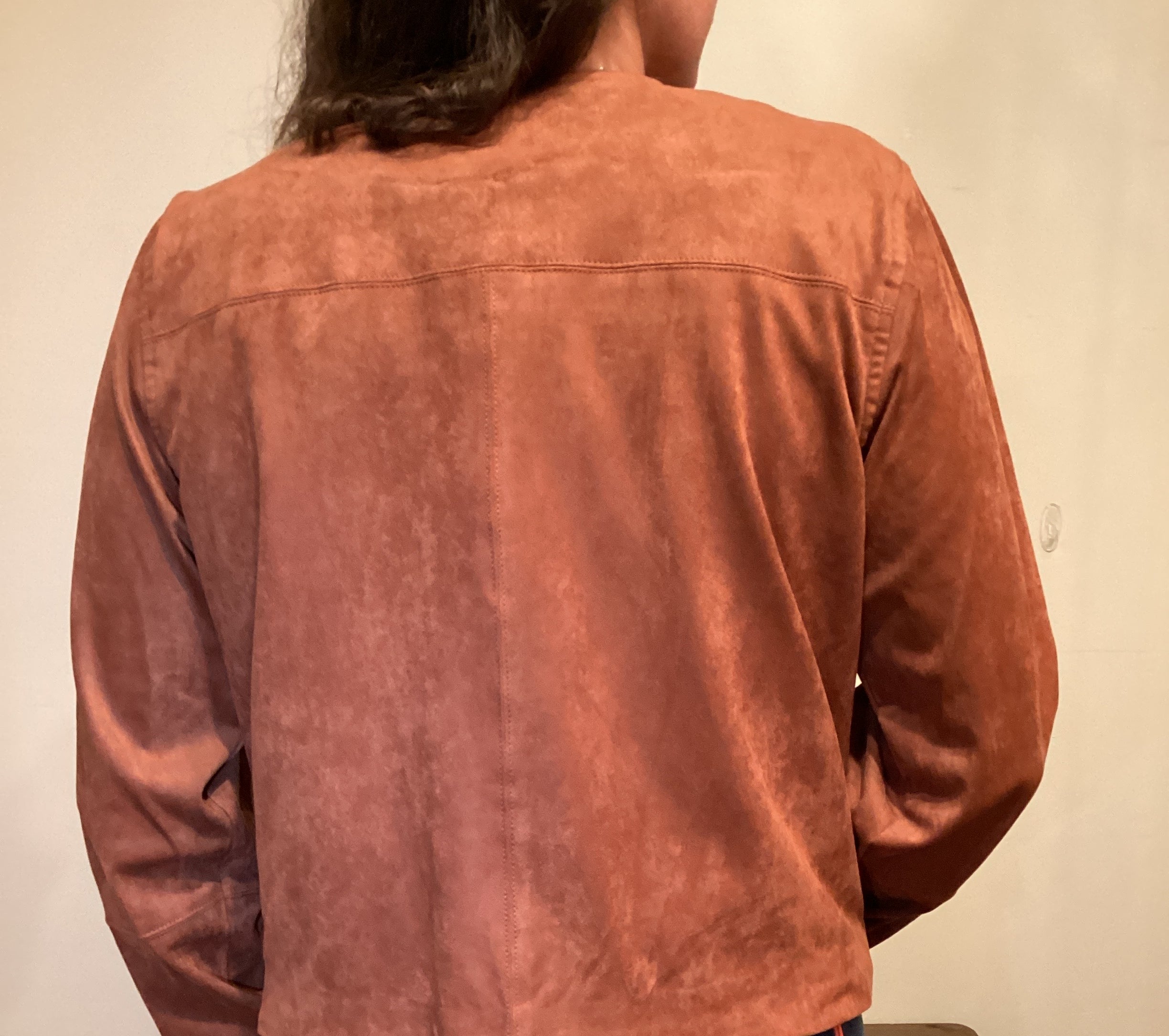 Back View Person wearing a brown faux leather button up jacket and blue jeans