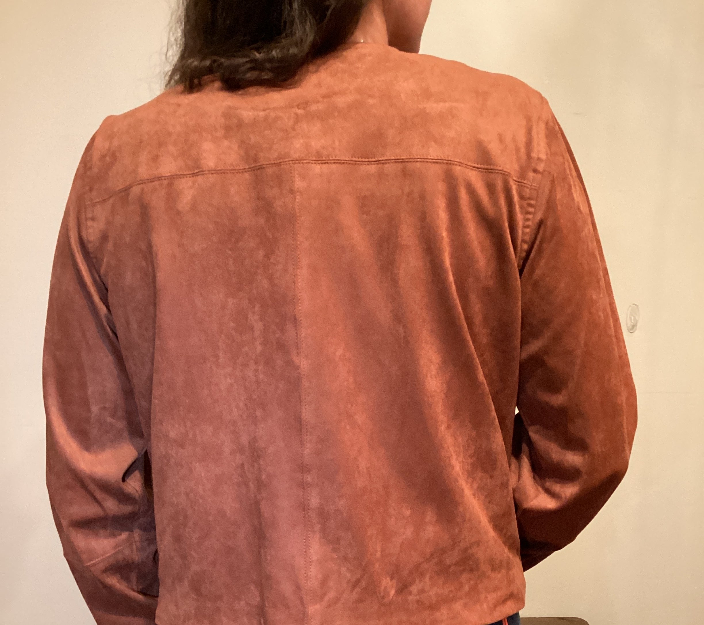 Back View Person wearing a brown faux leather button up jacket and blue jeans