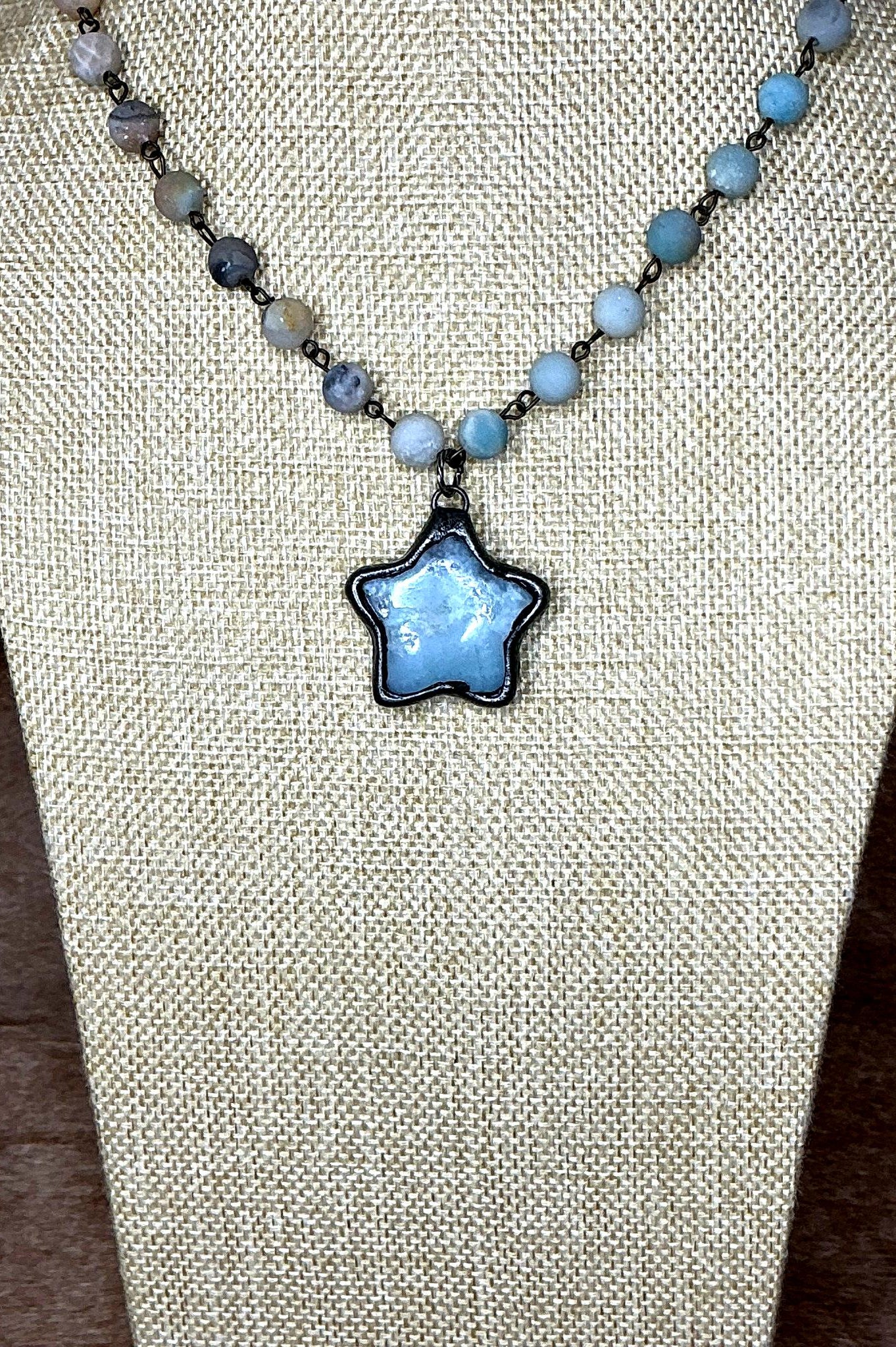 Necklace with a star-shaped pendant on a beige fabric background