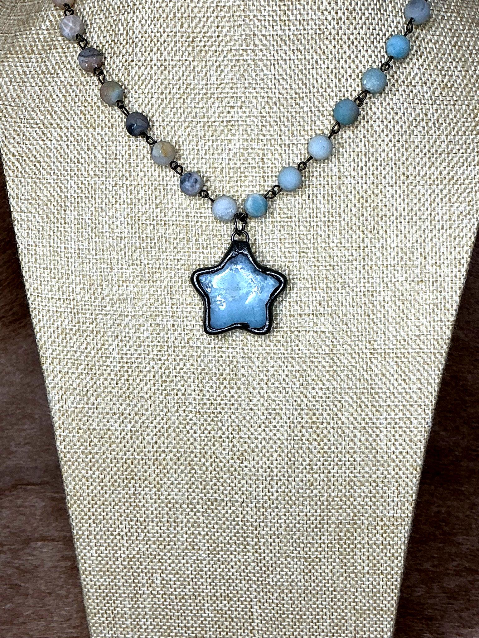 Necklace with a star-shaped pendant on a beige fabric background