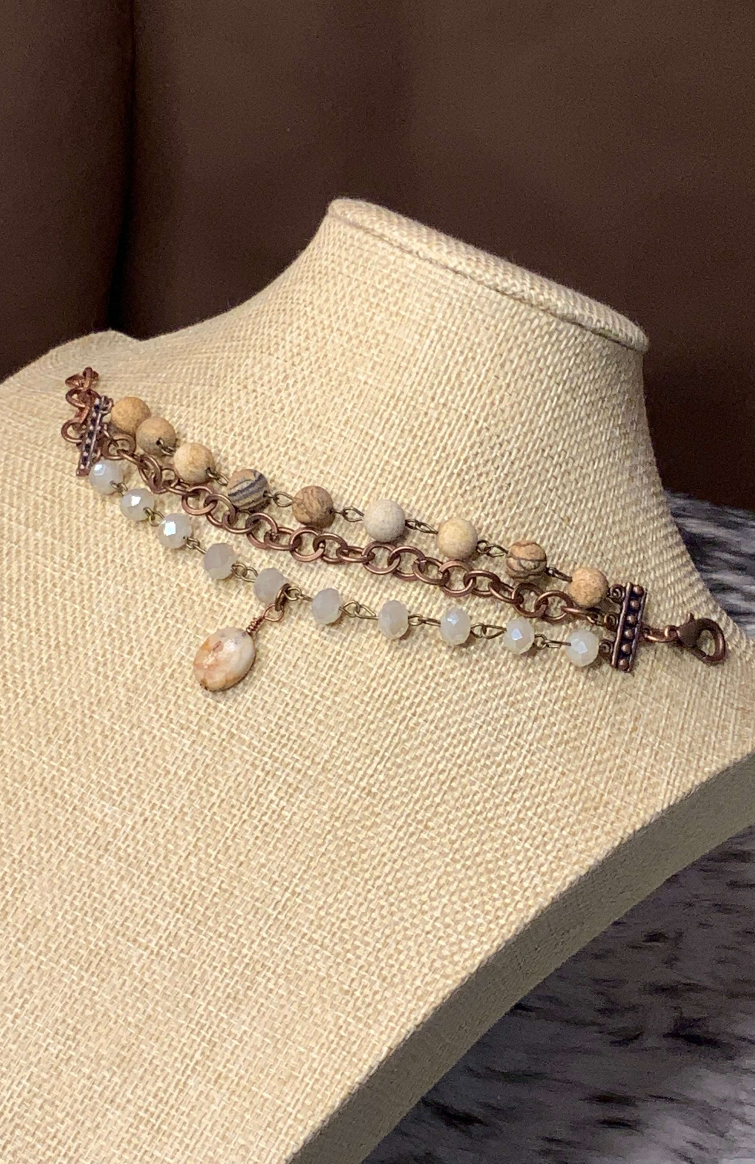 Aurora's Elegance Handcrafted Copper, Ivory Crystals, and Agate Stone Bracelet displayed on a mannequin bust with a neutral background.