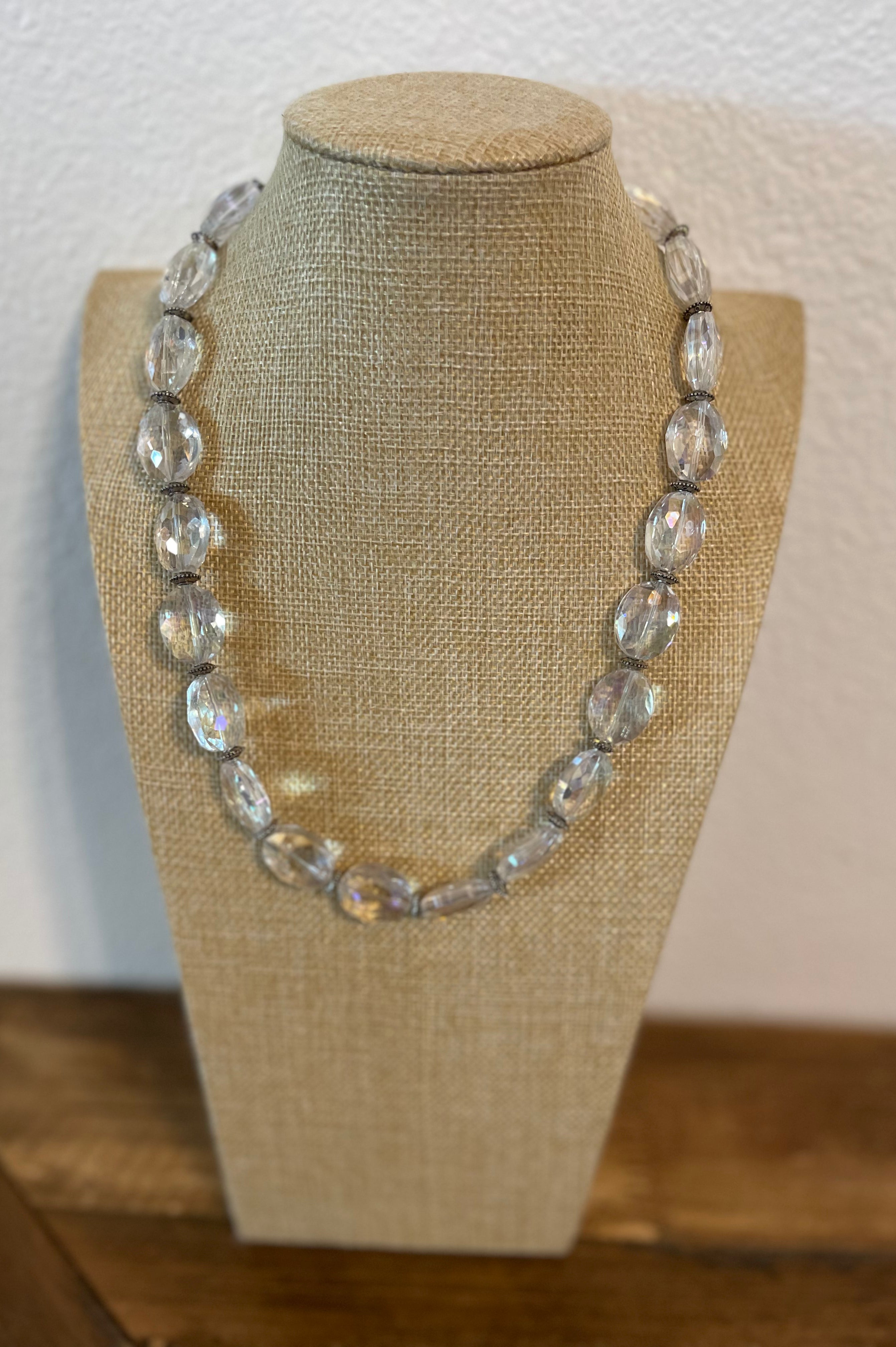 Necklace on a mannequin bust with a plain background