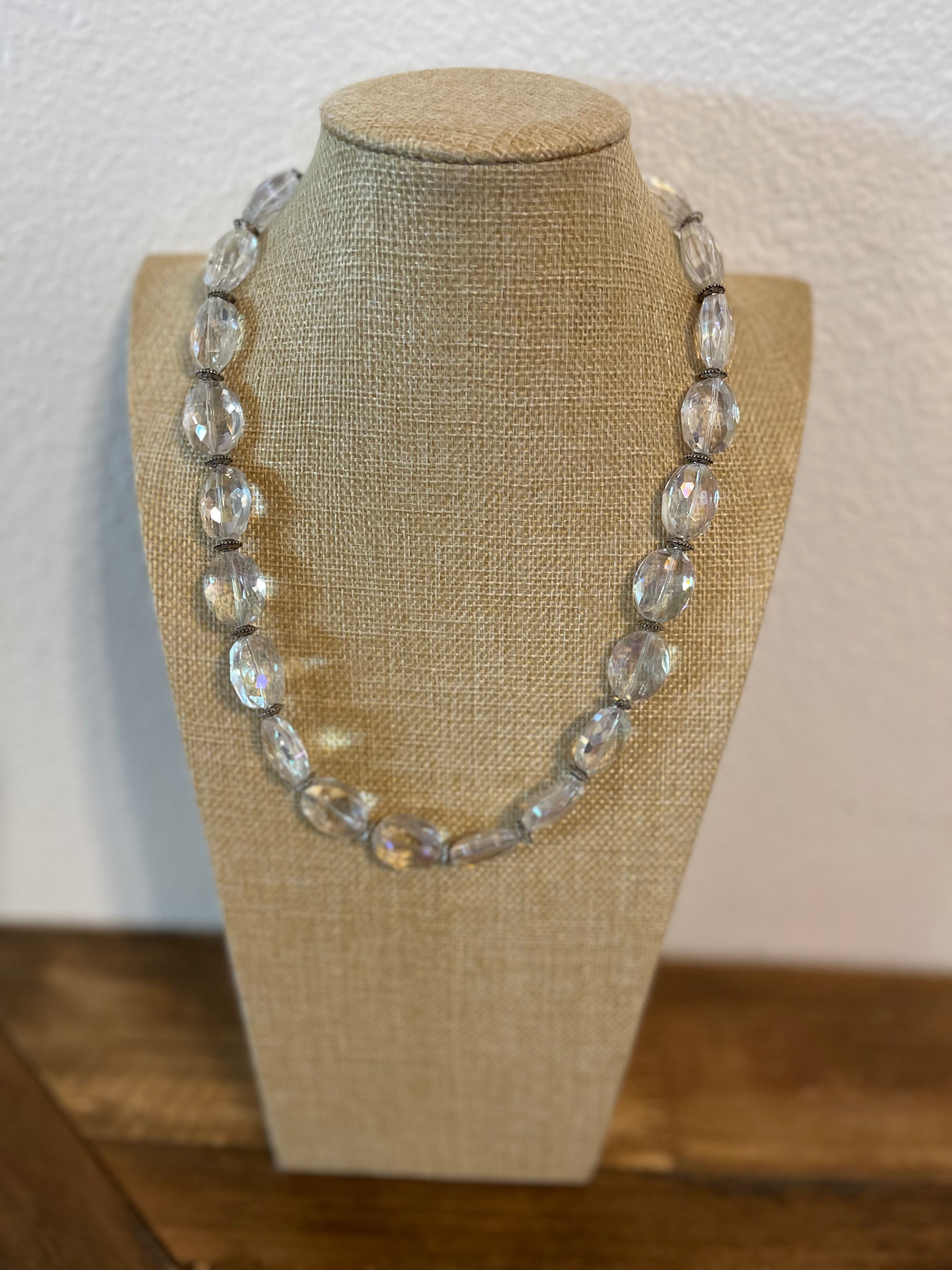 Necklace on a mannequin bust with a plain background