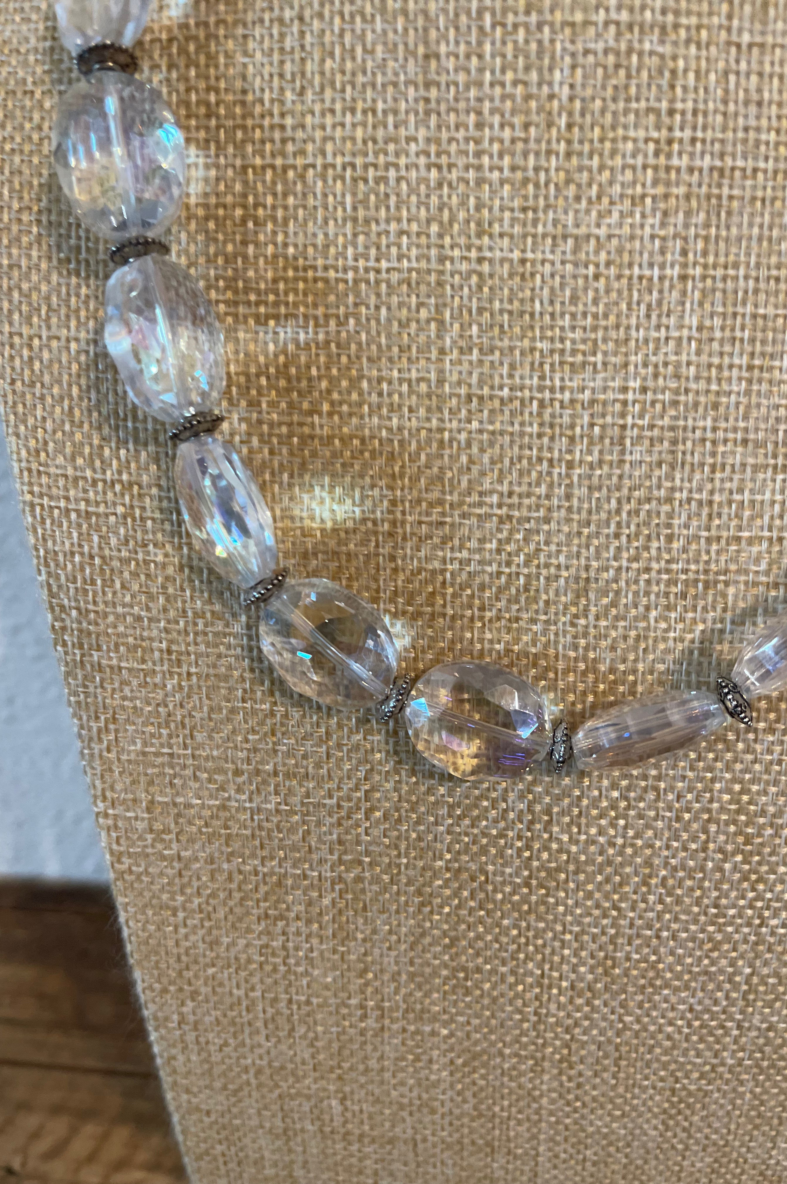 Necklace with clear and brown beads on a textured beige background