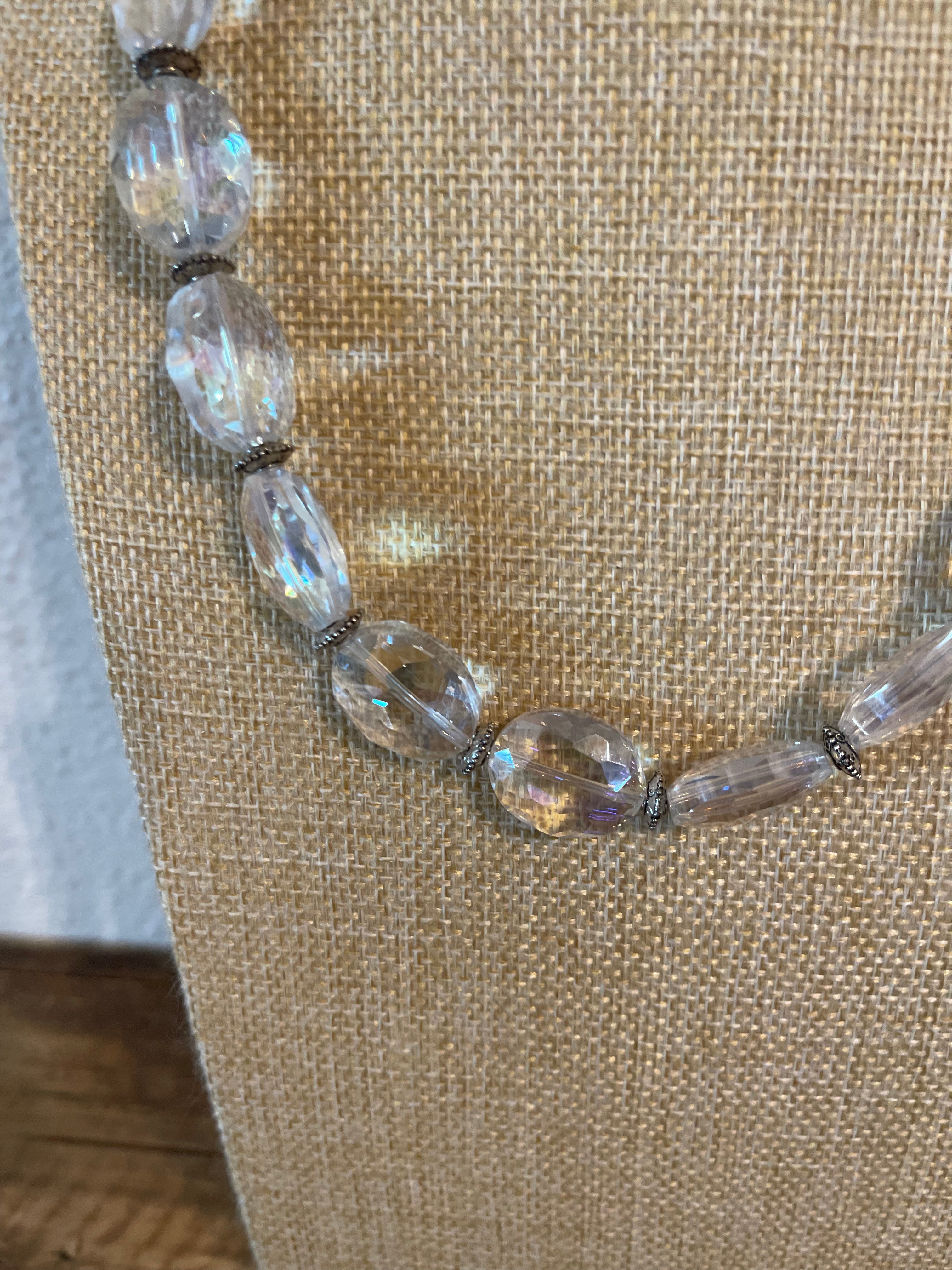 Necklace with clear and brown beads on a textured beige background