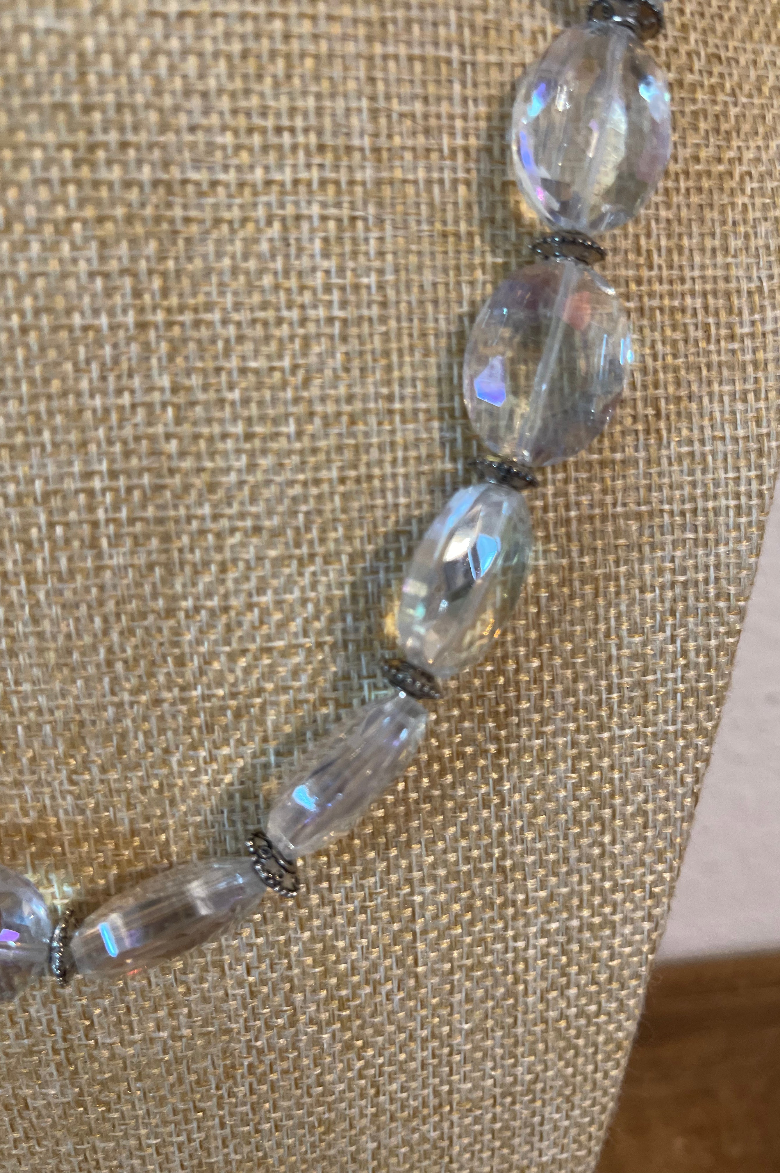 Necklace with clear beads on a textured beige background