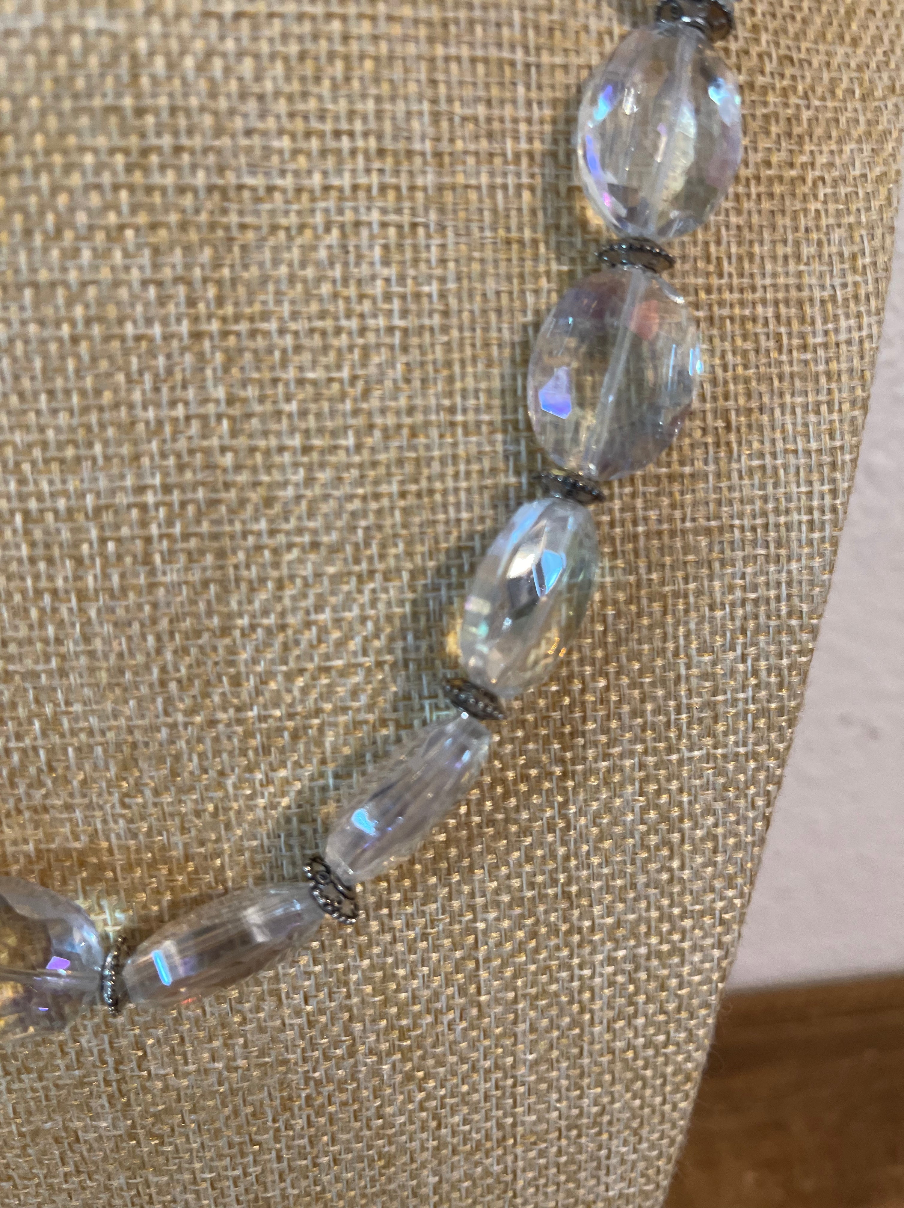 Necklace with clear beads on a textured beige background