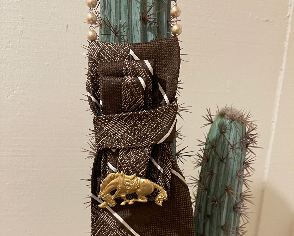 Handcrafted vintage tie necklace by Copper & Lace Western Boutique featuring an authentic 1970s brown patterned necktie, champagne pearl strand, and vintage gold-tone horse brooch.