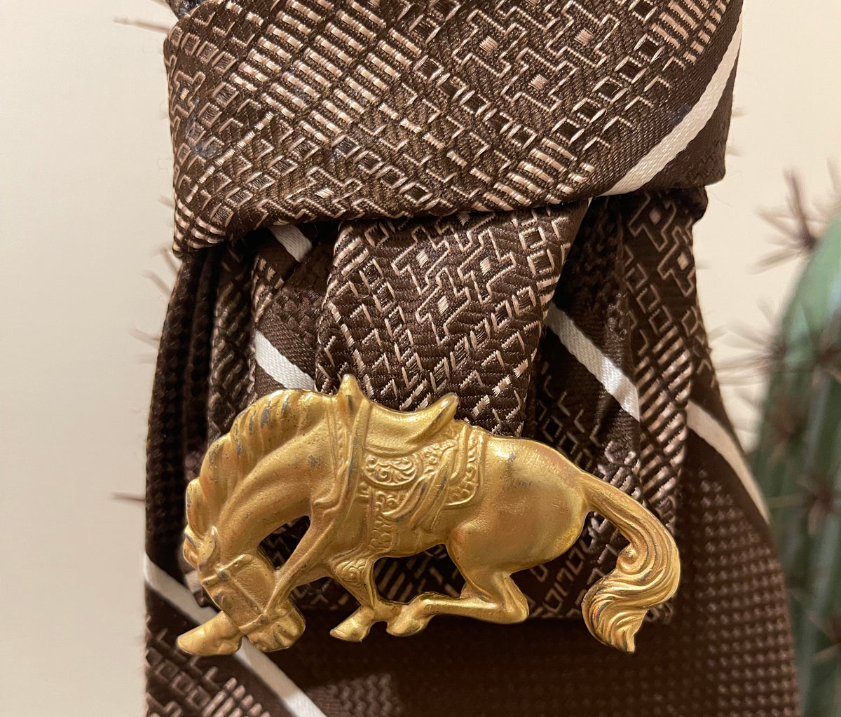 Handcrafted vintage tie necklace by Copper & Lace Western Boutique featuring an authentic 1970s brown patterned necktie, champagne pearl strand, and vintage gold-tone horse brooch.
