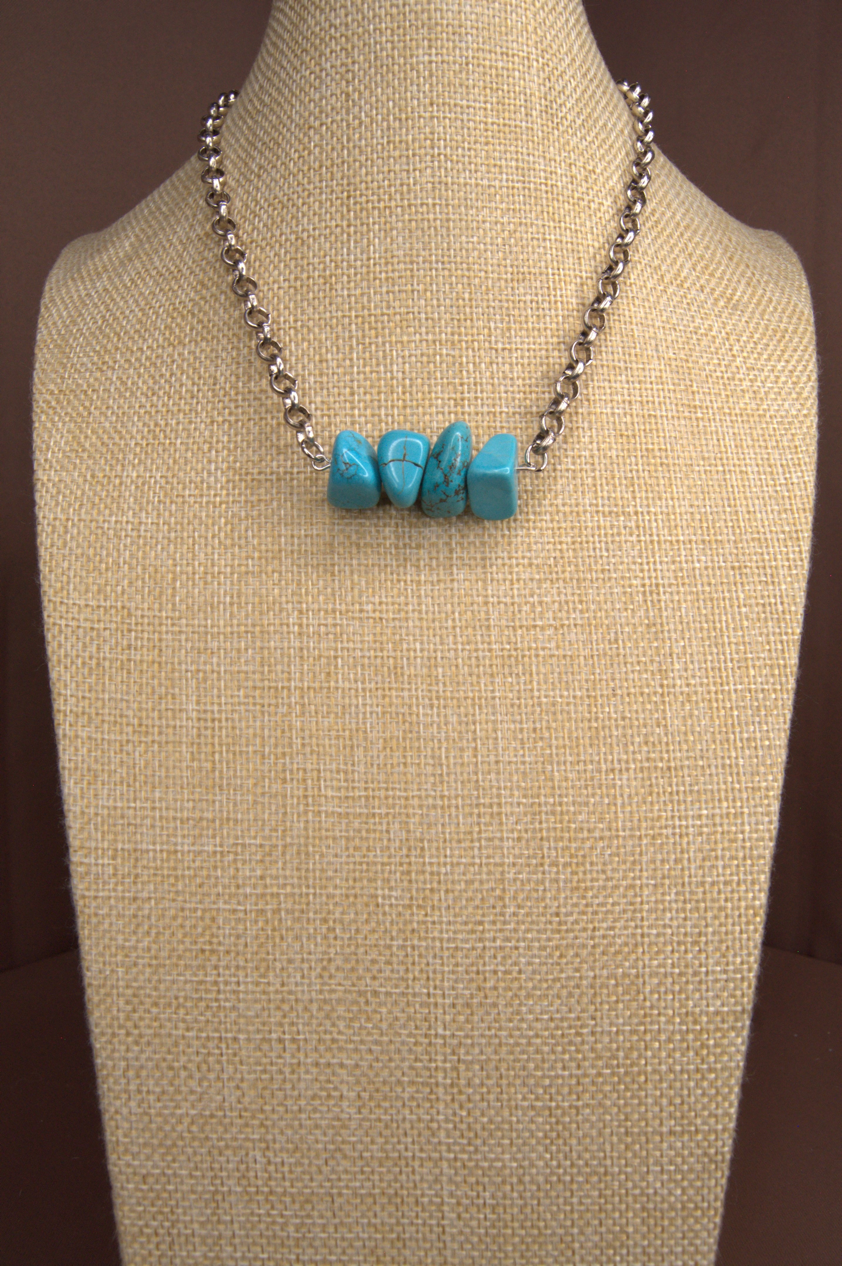 Necklace with turquoise stones on a beige mannequin