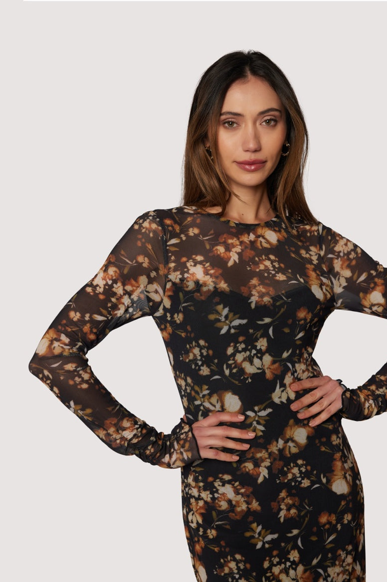Woman wearing a floral dress against a plain background