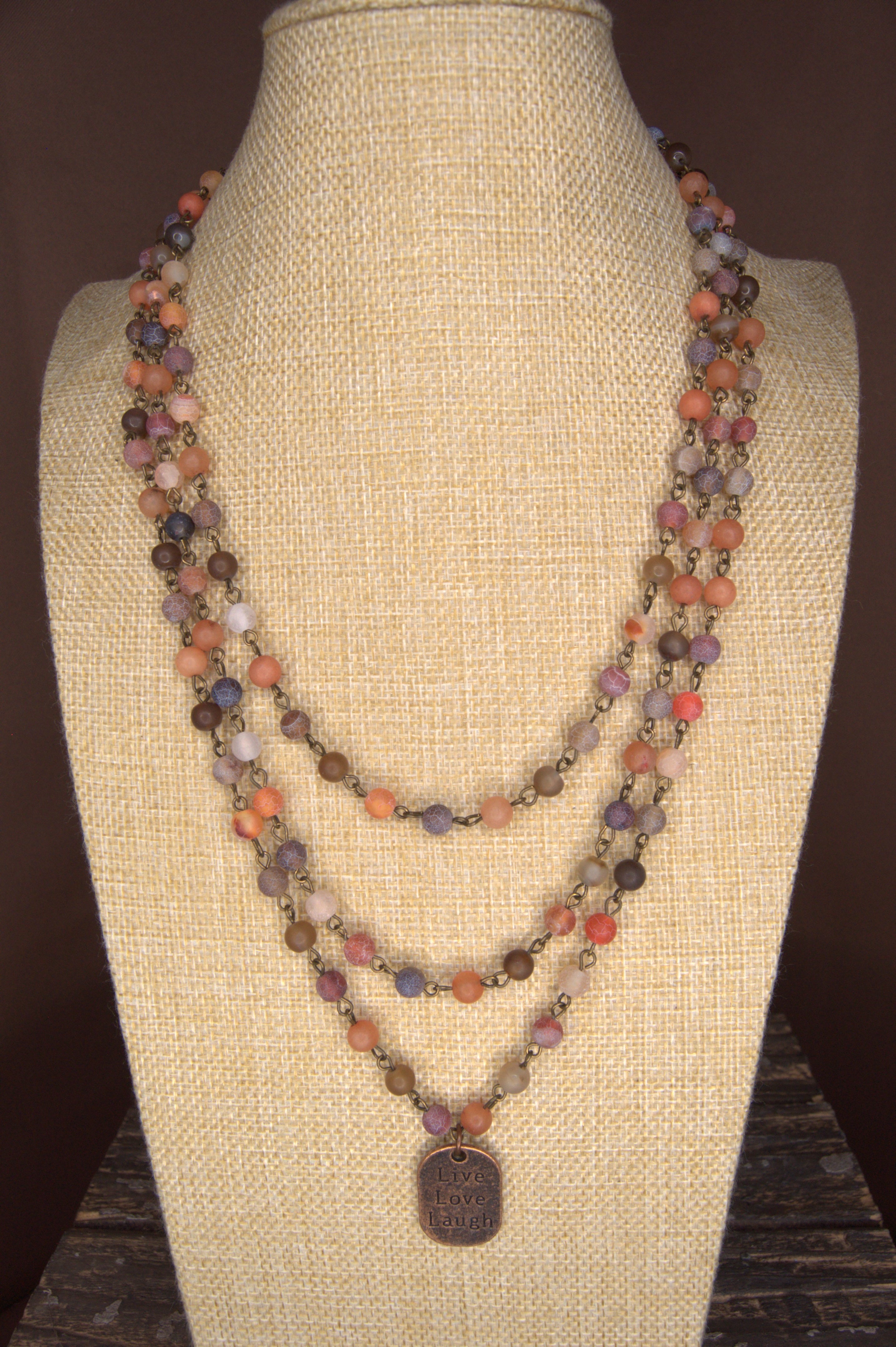 bust with a 2 strand 6mm beaded necklace in 6mm Red Moss, Orange-Red Moss, and Brown Line Matte Agate beads with a copper tag stamped with Live Love Laugh