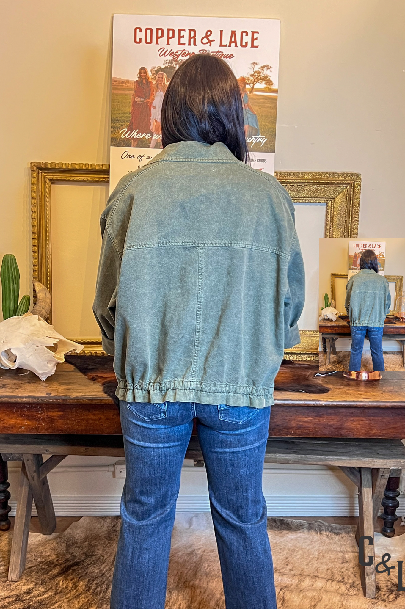 Person wearing a denim jacket and jeans standing in front of a mirror with a 'Copper & Lace' poster on the wall.