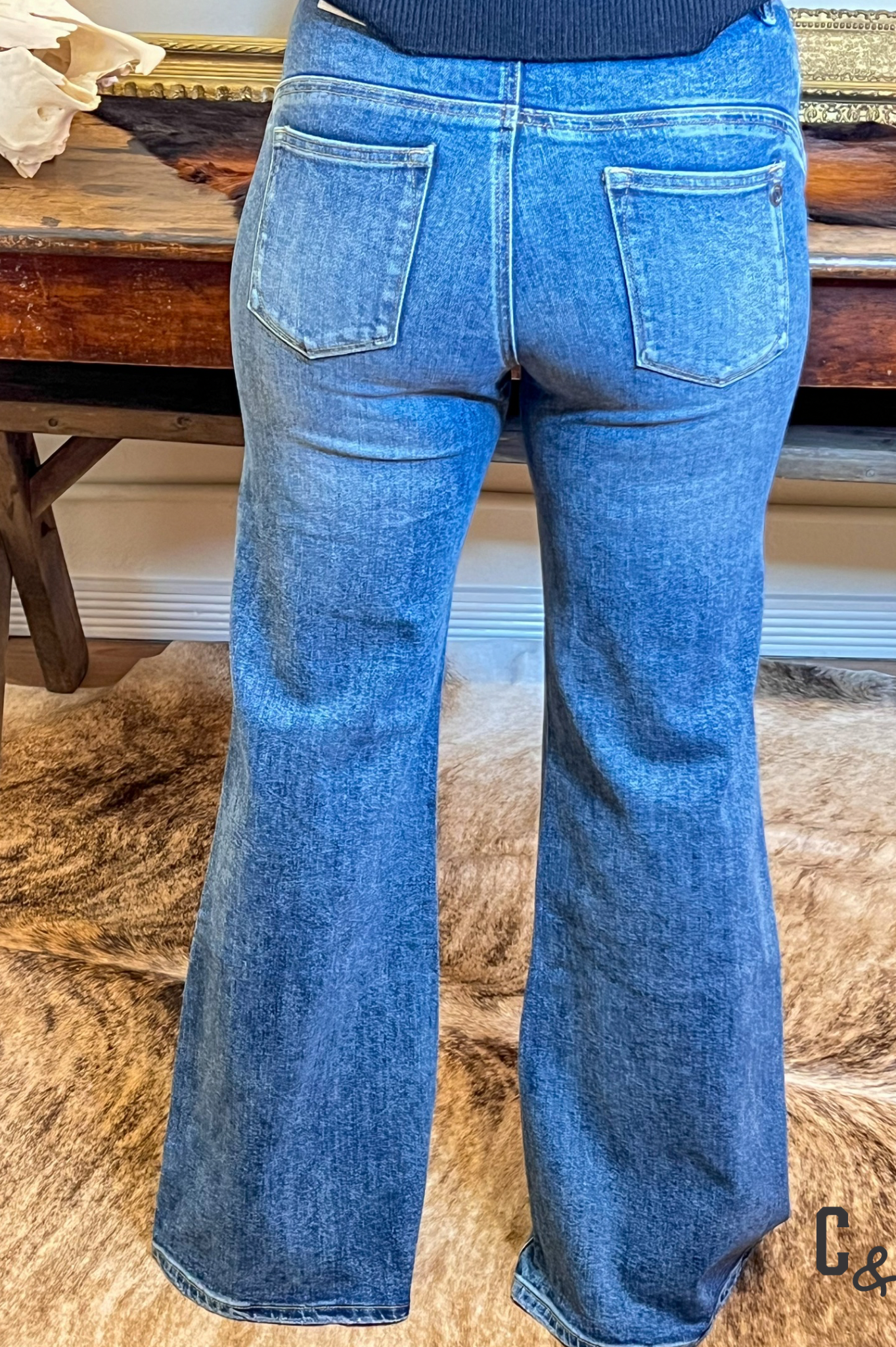 Blue flared jeans on a wooden surface with a blurred background