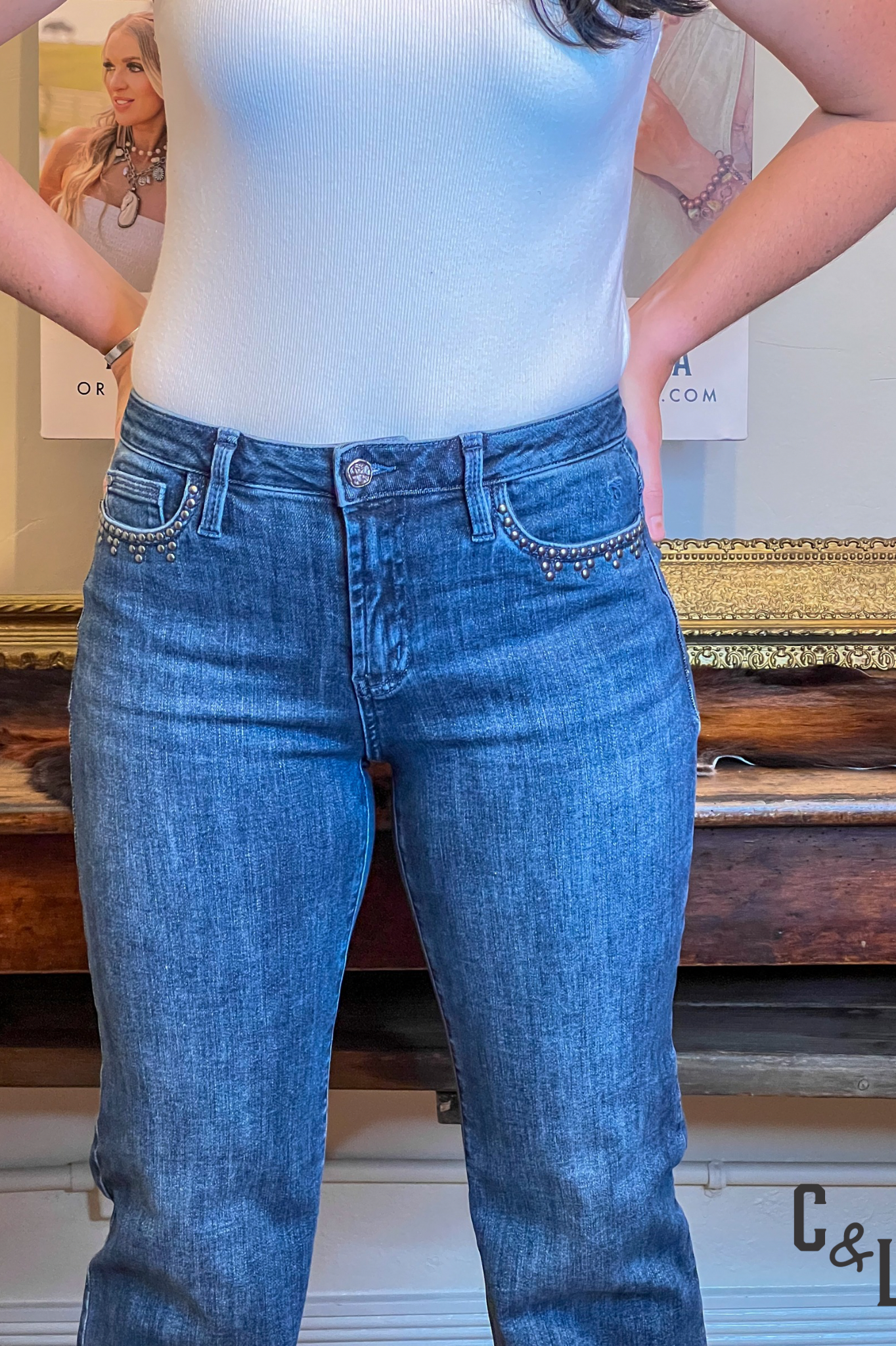 Person wearing blue jeans and a light blue top in an indoor setting with a blurred background