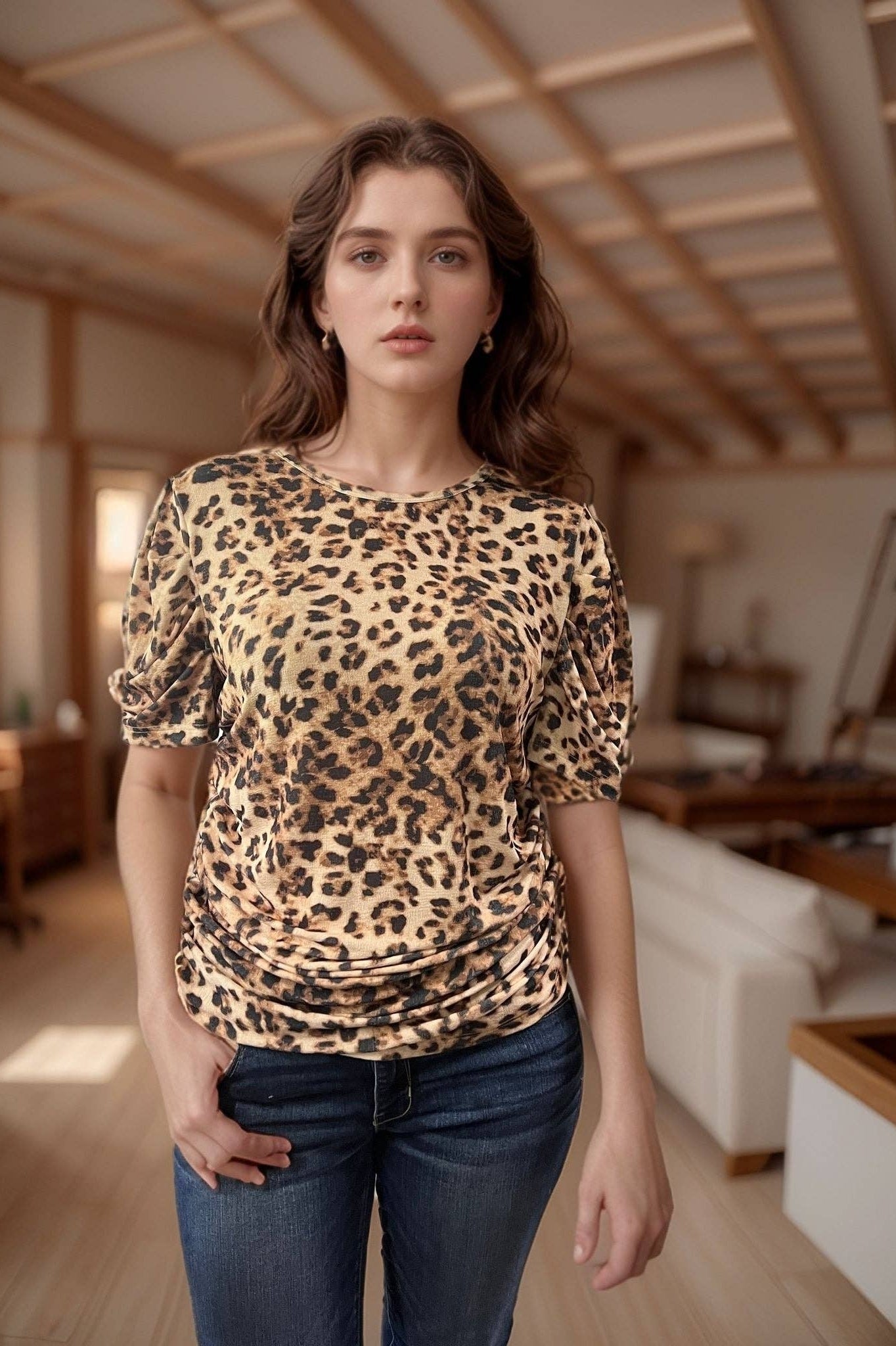Woman wearing a leopard print top and blue jeans in a room with wooden beams.